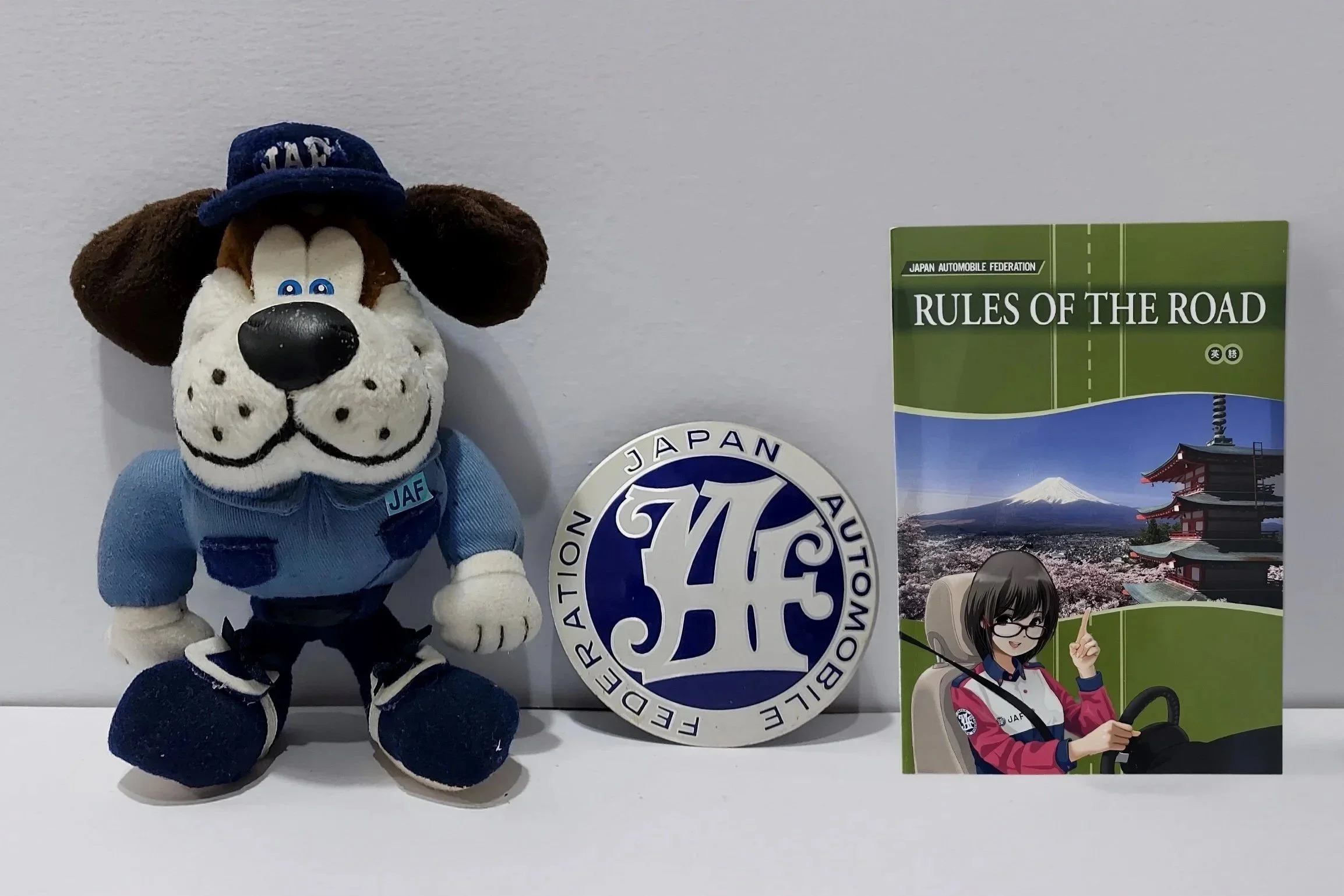 Photo of JAL dog mascot, badge and Rules of the Road booklet
