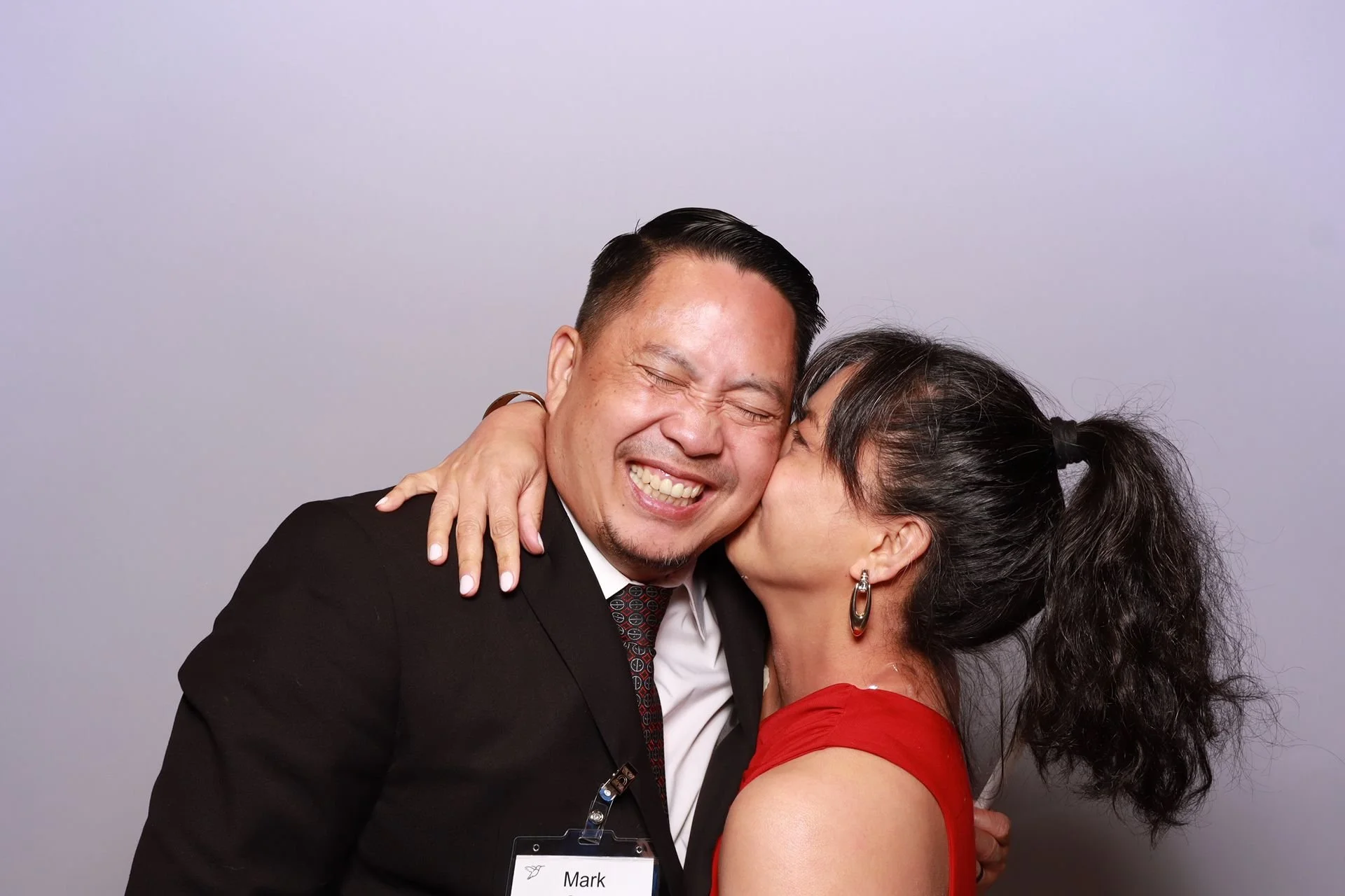 Couple kissing inside the photo booth at a corporate event in Portland.
