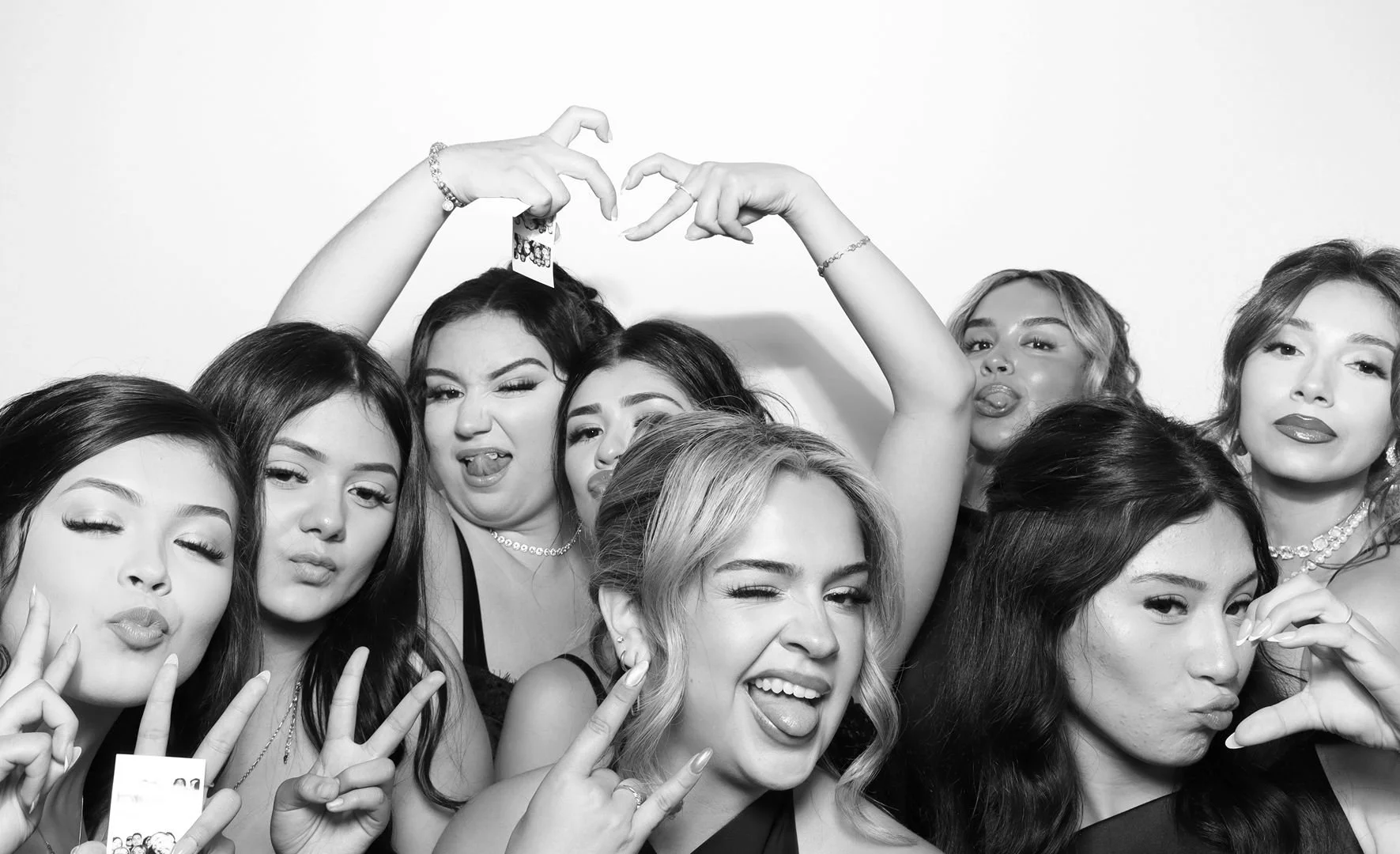 Multigenerational wedding guests using a glam photo booth at an outdoor reception in Oregon.