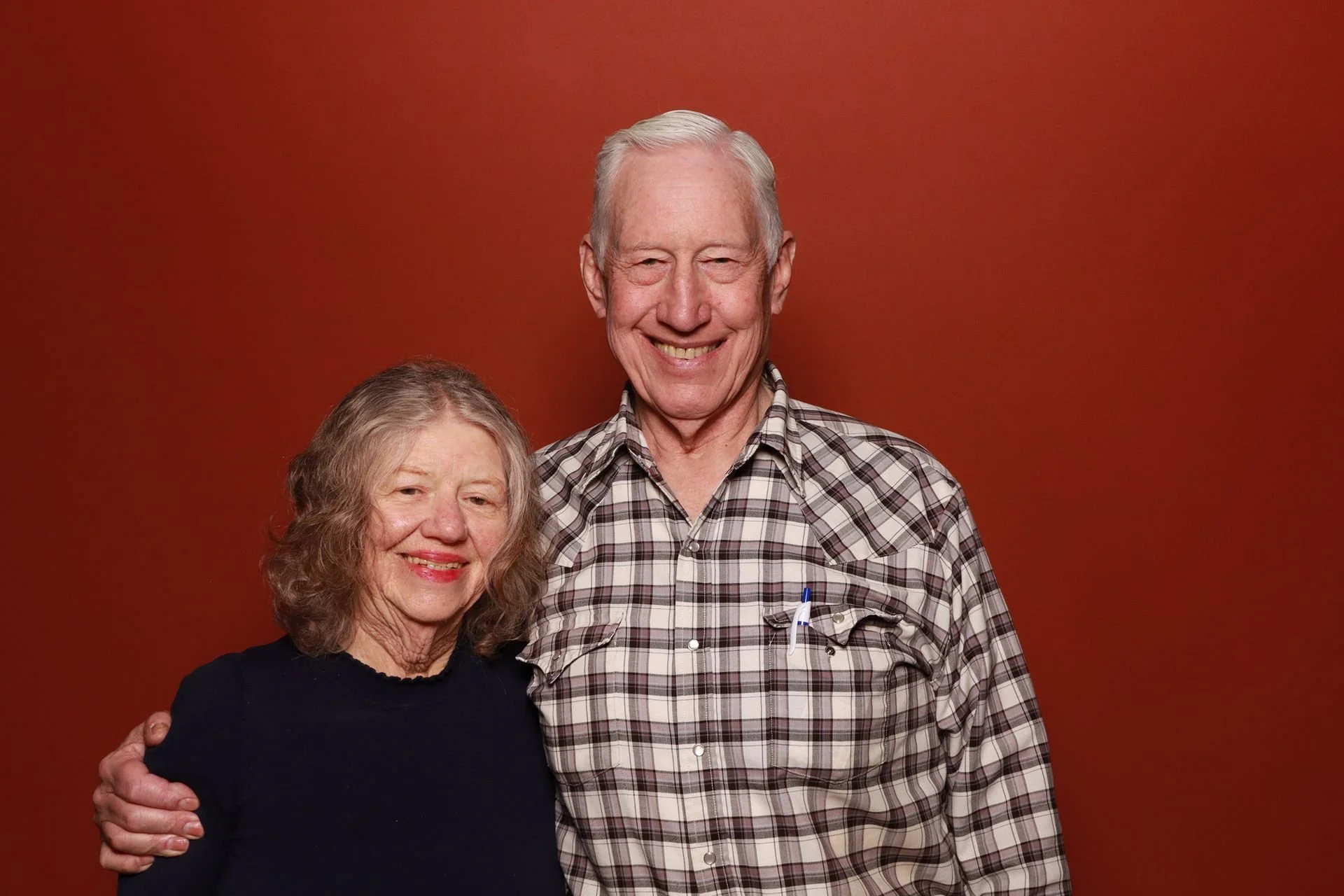 Husband and wife posing for photo booth at a tradeshow in Portland.