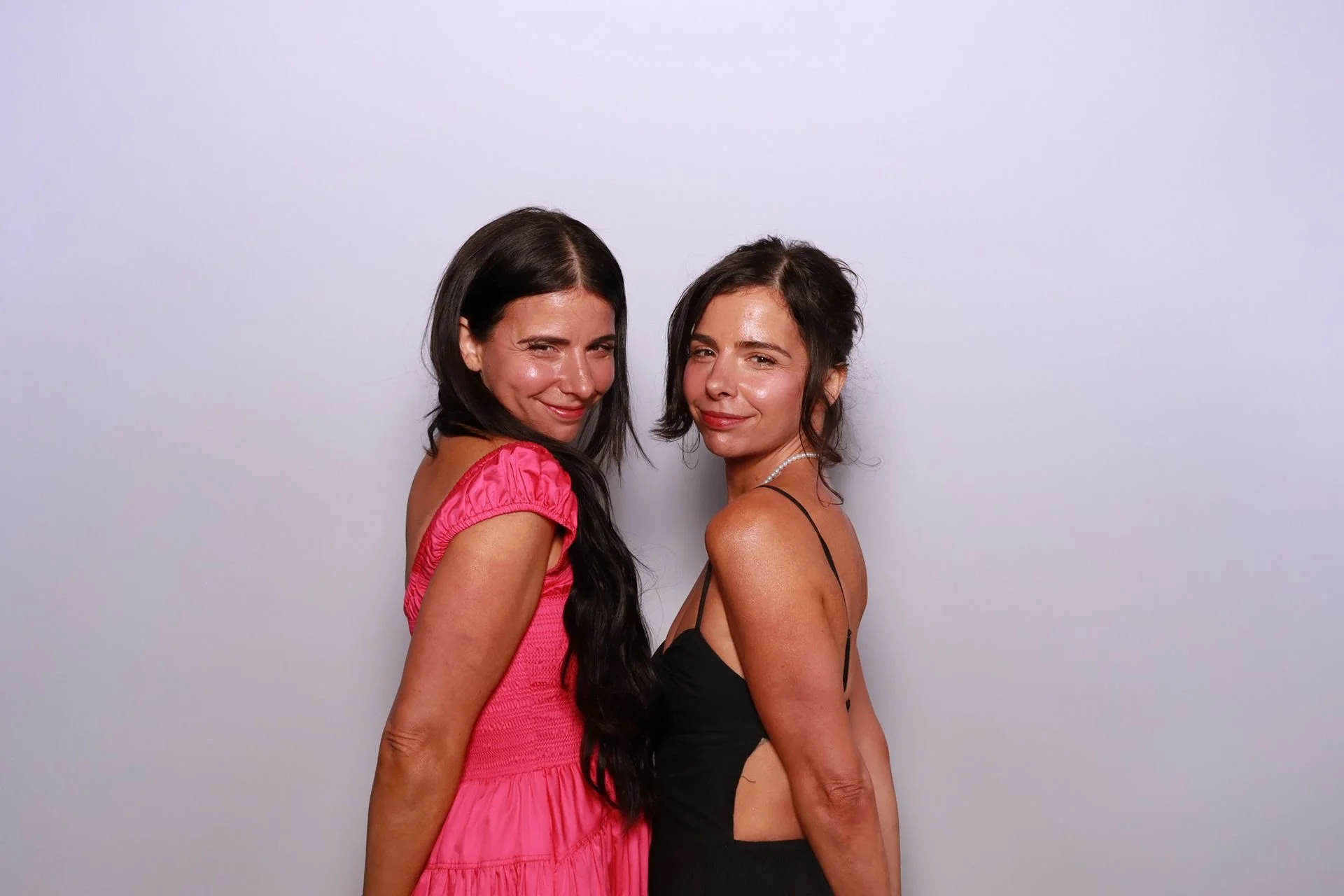 Sisters posing in a photo booth at a gala in Portland Oregon.
