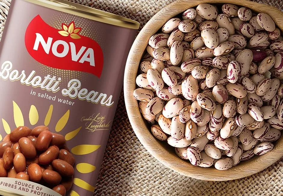 Can of Nova Borlotti Beans in salted water beside wooden bowl of dried beans on fabric surface – imported canned legumes supplied by Jetha Australian food importers