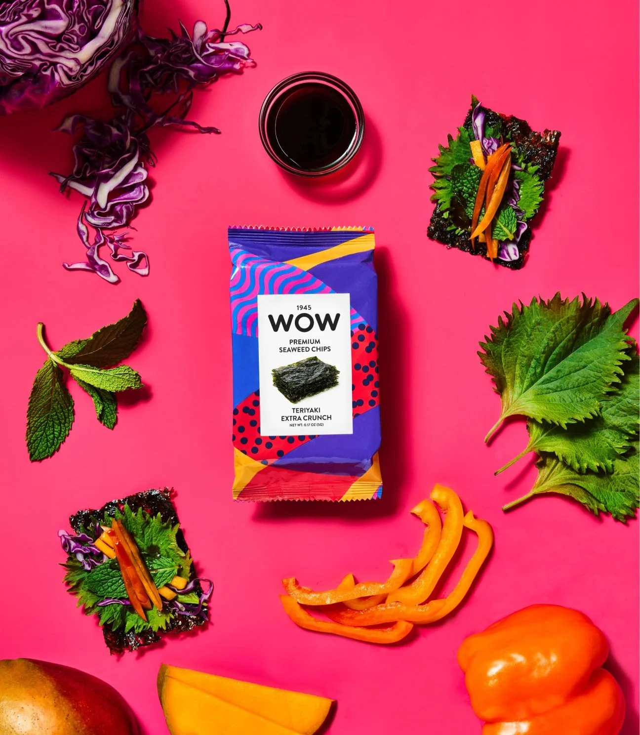 WOW Seaweed Snack flat lay with vegetables, greens, and soy sauce on bright pink background – imported healthy snacks supplied by Jetha Australian food importers