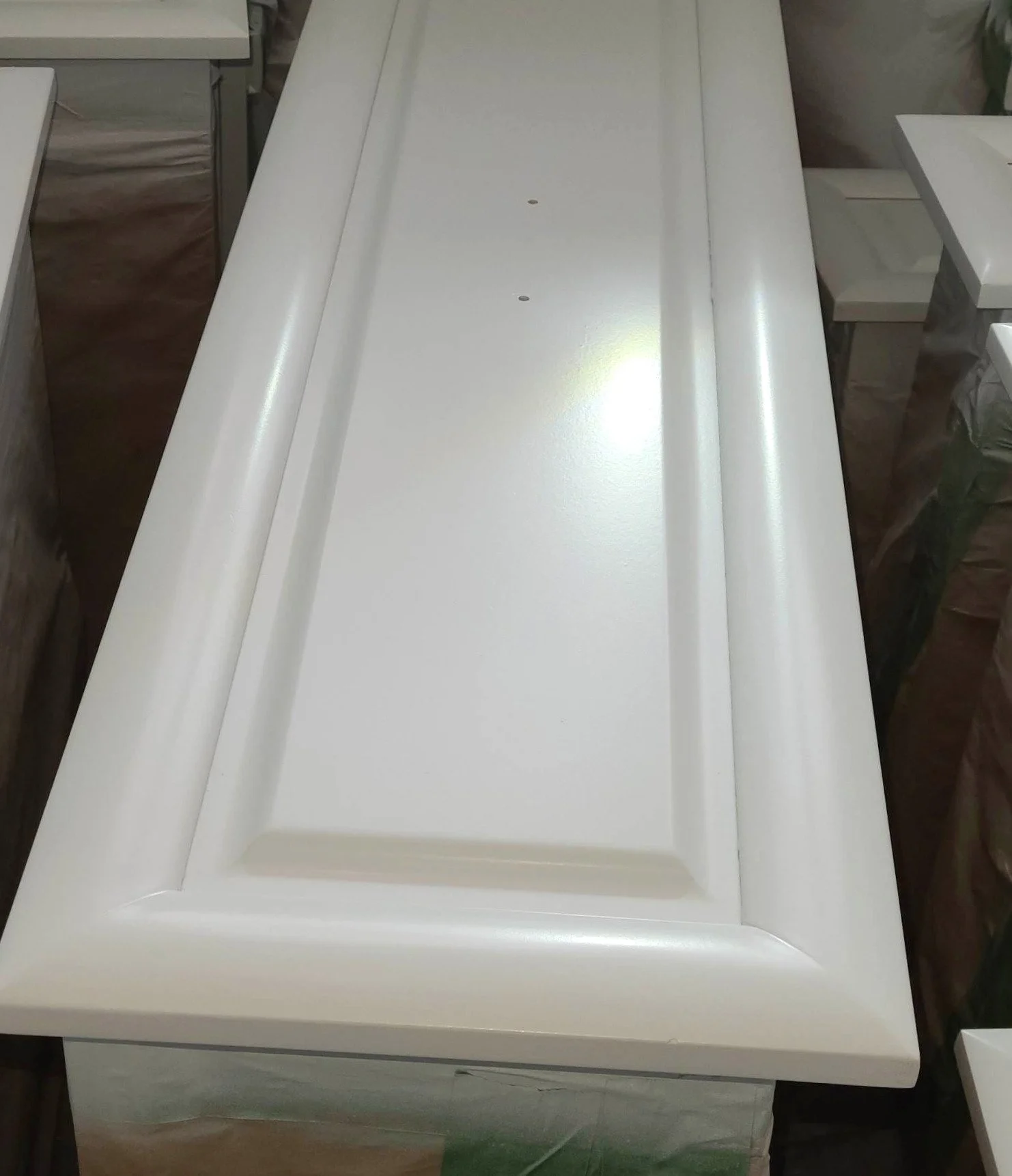 Fini lisse et uniforme obtenu au pistolet HVLP sur une porte d'armoire de cuisine repeinte