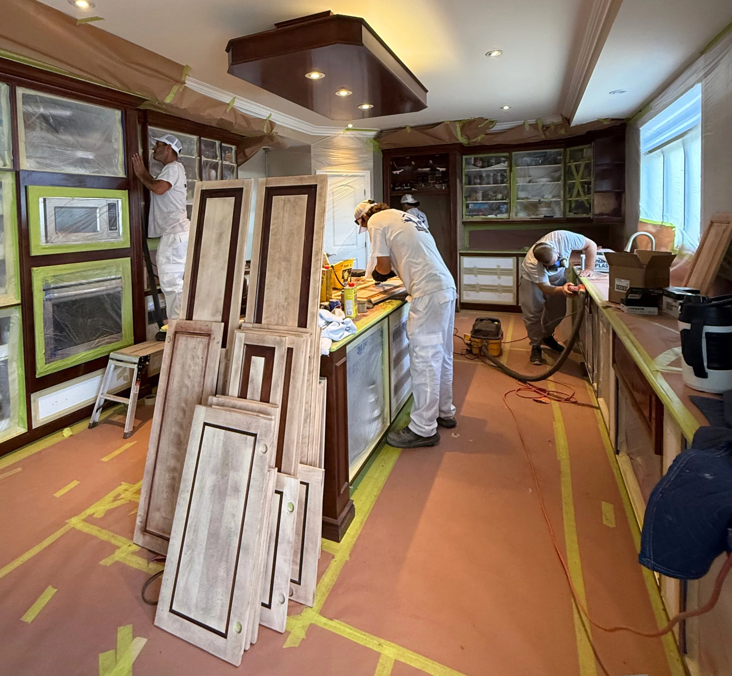 Portes d’armoires de cuisine décapées jusqu’au bois nu avant l’application de la nouvelle teinture