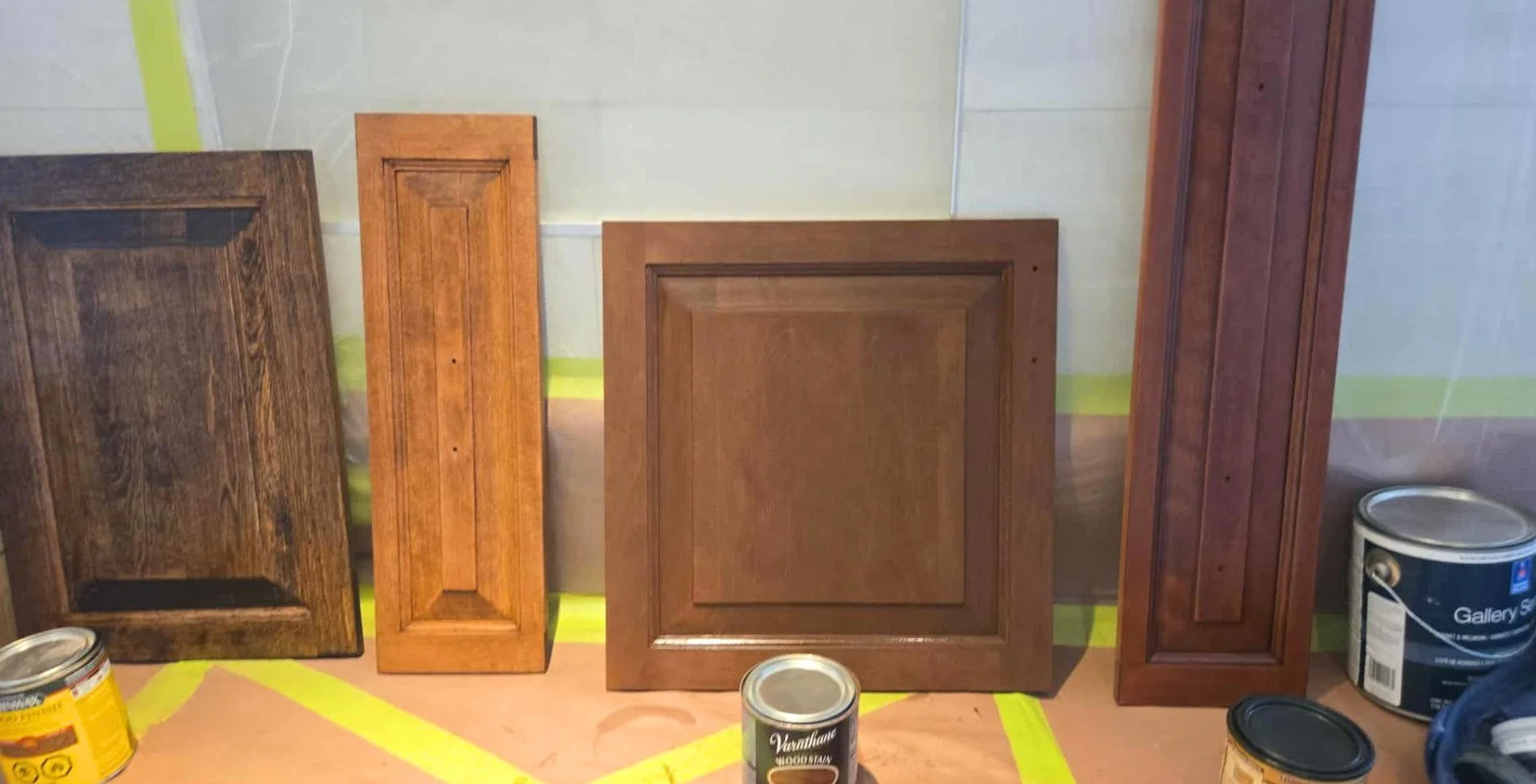 Tests de teinte appliqués sur une porte d’armoire en bois massif décapée avant le choix de la couleur