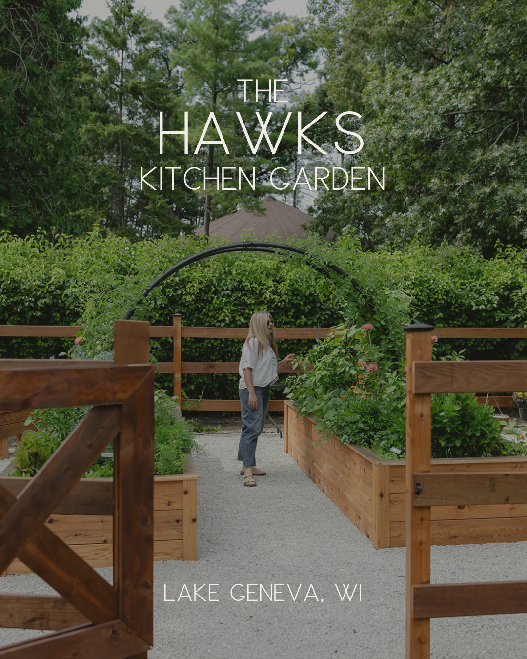 The Hawks Kitchen Garden in Lake Geneva, Wisconsin, with cedar raised beds, a gated entrance, white gravel pathways, and a custom black arch trellis.