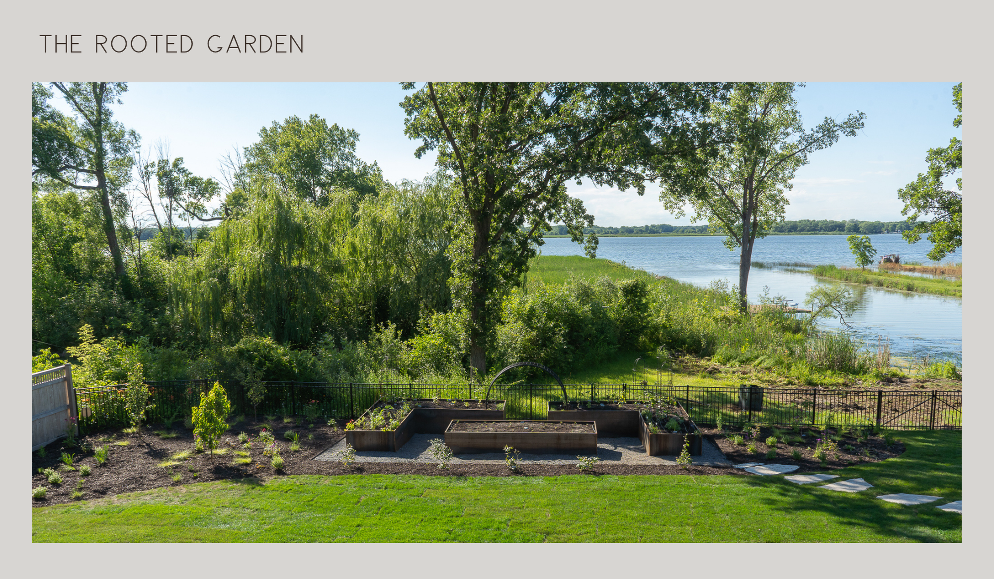 The Rooted Garden overlooking the lake, with corten steel raised beds framed by mature trees and lush landscaping.