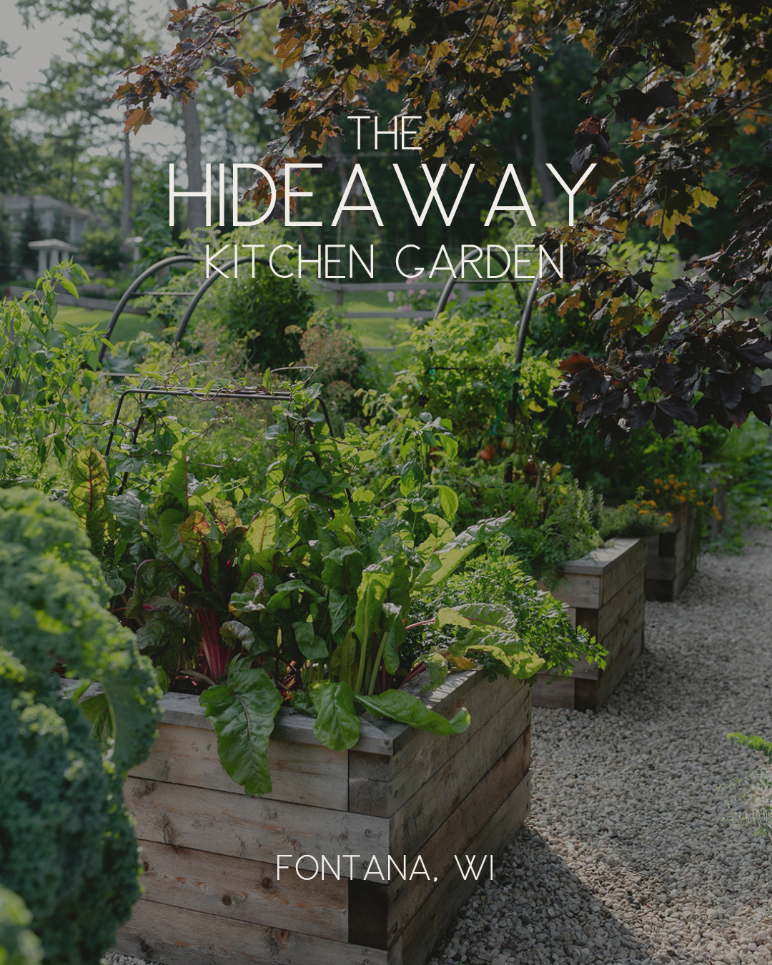 The Hideaway Kitchen Garden in Fontana, Wisconsin, with abundant cedar raised beds, custom black trellises, gravel pathways, and lush vegetables and herbs.