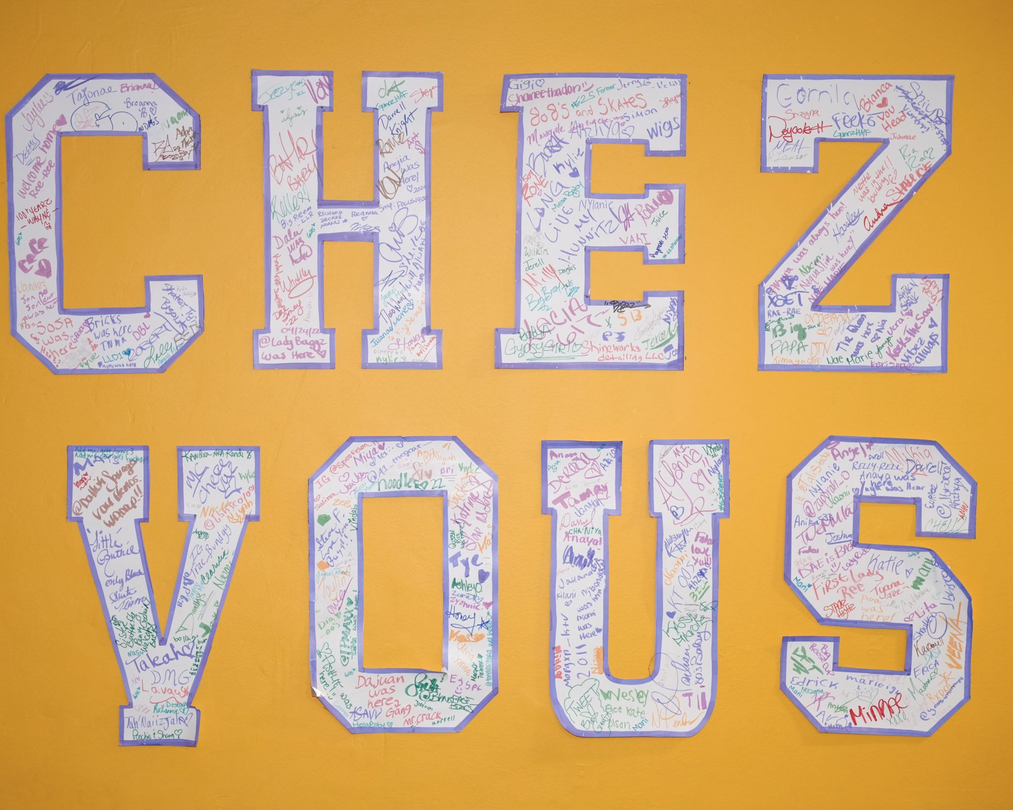 Sign with large block letters spelling 'CHICAGO' and 'VOLS,' filled with colorful signatures and messages on a yellow background.