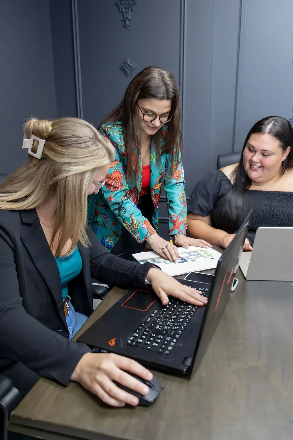 Trois femmes travaillant sur un meuble brun foncé