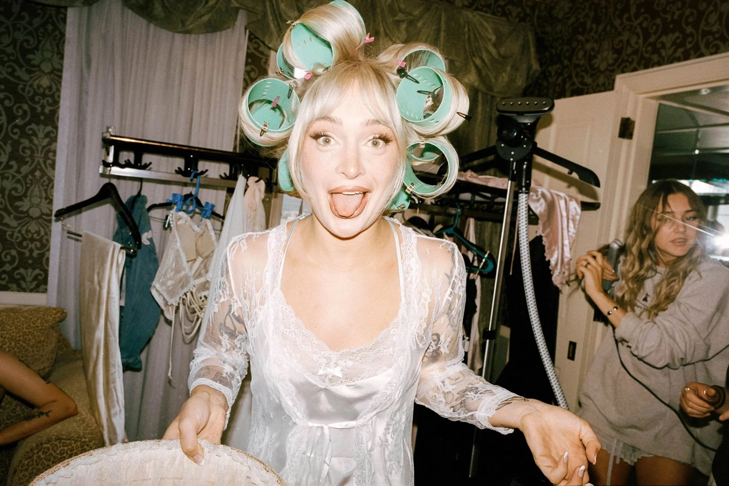 bride with rollers in hair during wedding prep