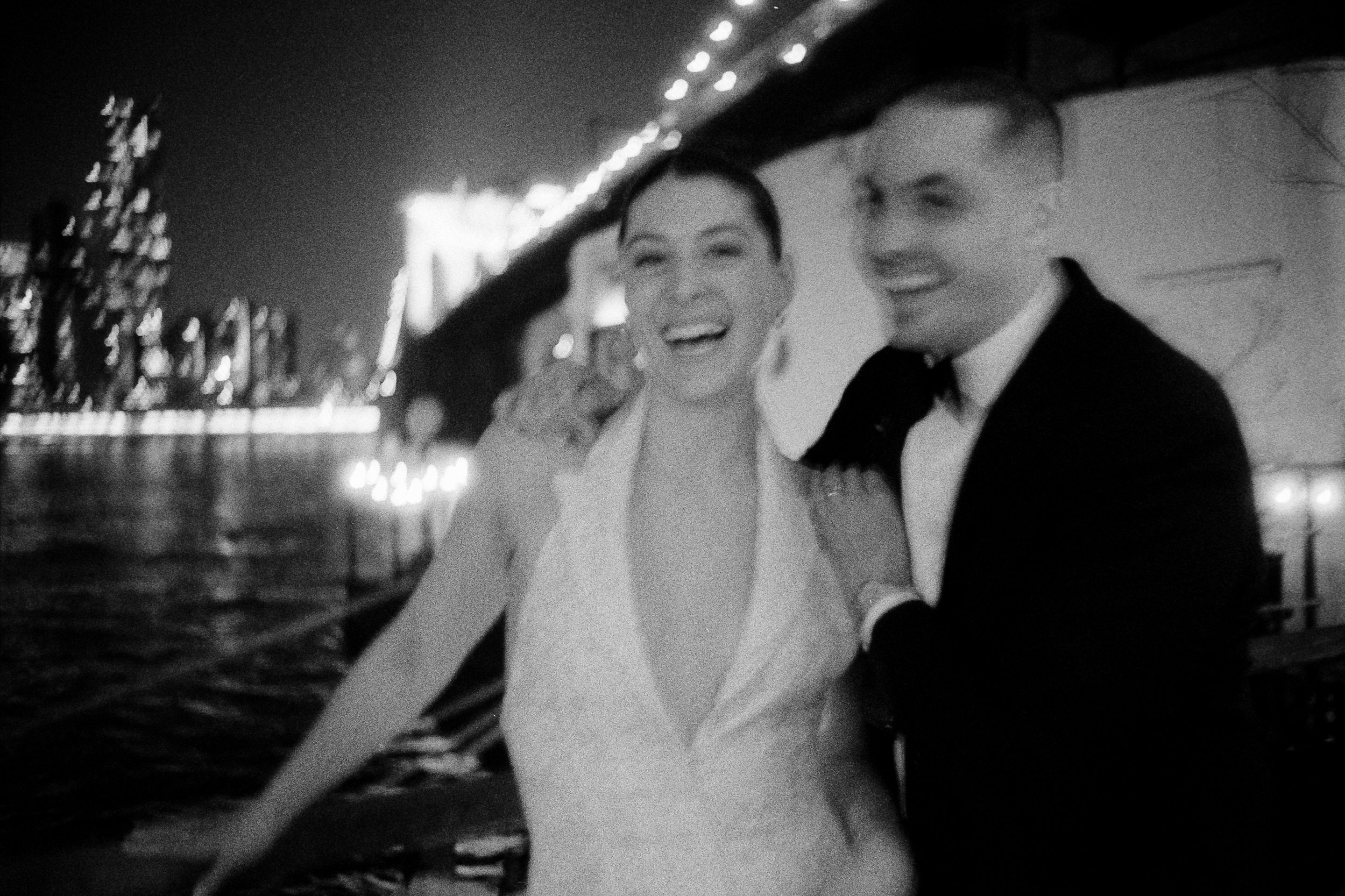 bride and groom black and white blurry film at river cafe Brooklyn NYC skyline nighttime