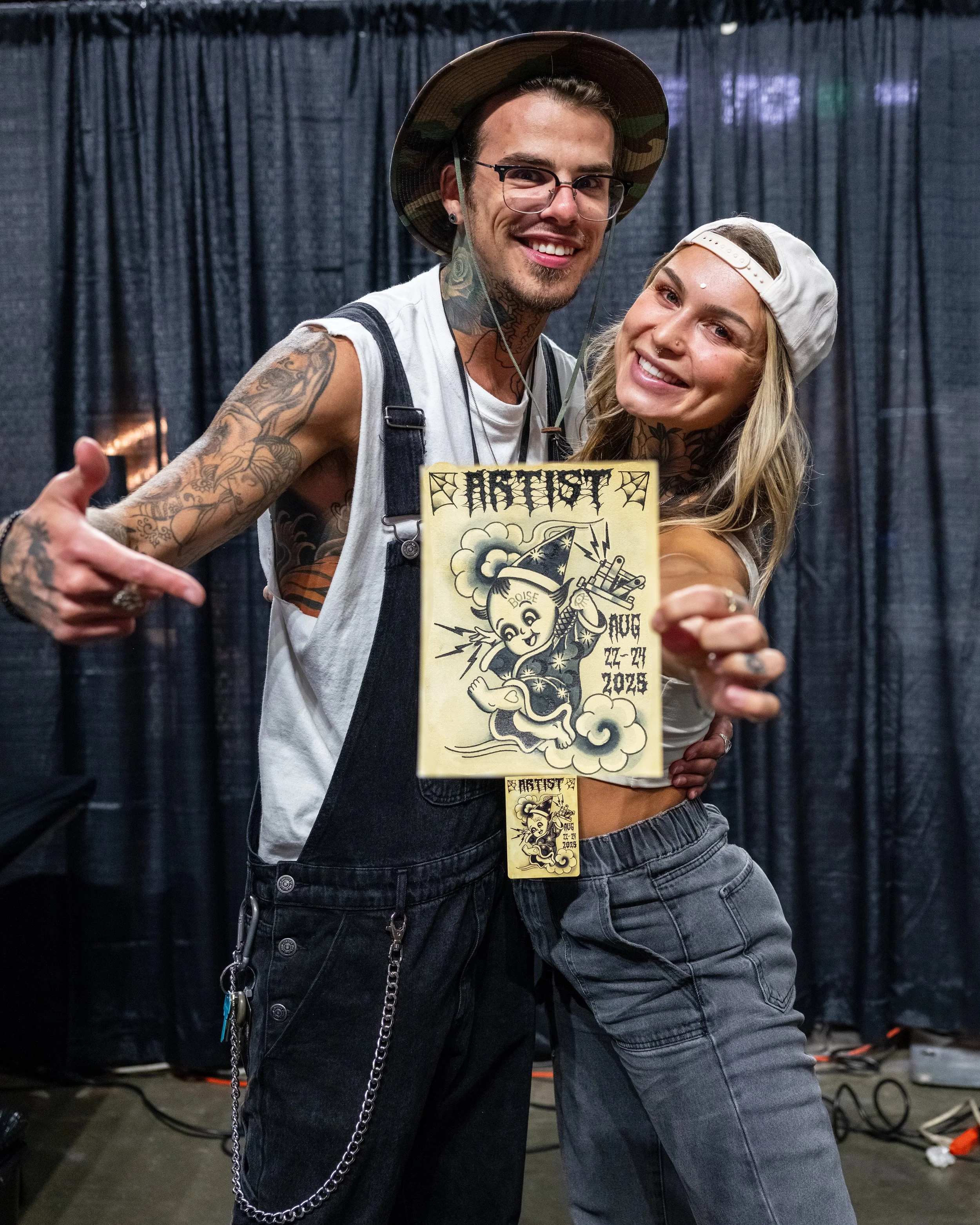 Winners or the original artwork of 2025's artist badge made by artist Andrew Pontius. Tyler and Karly Andrews. The original artwork was raffled off and all proceeds went to the West Valley Humane Society. Photo by Nick Hedden @gemstatephoto