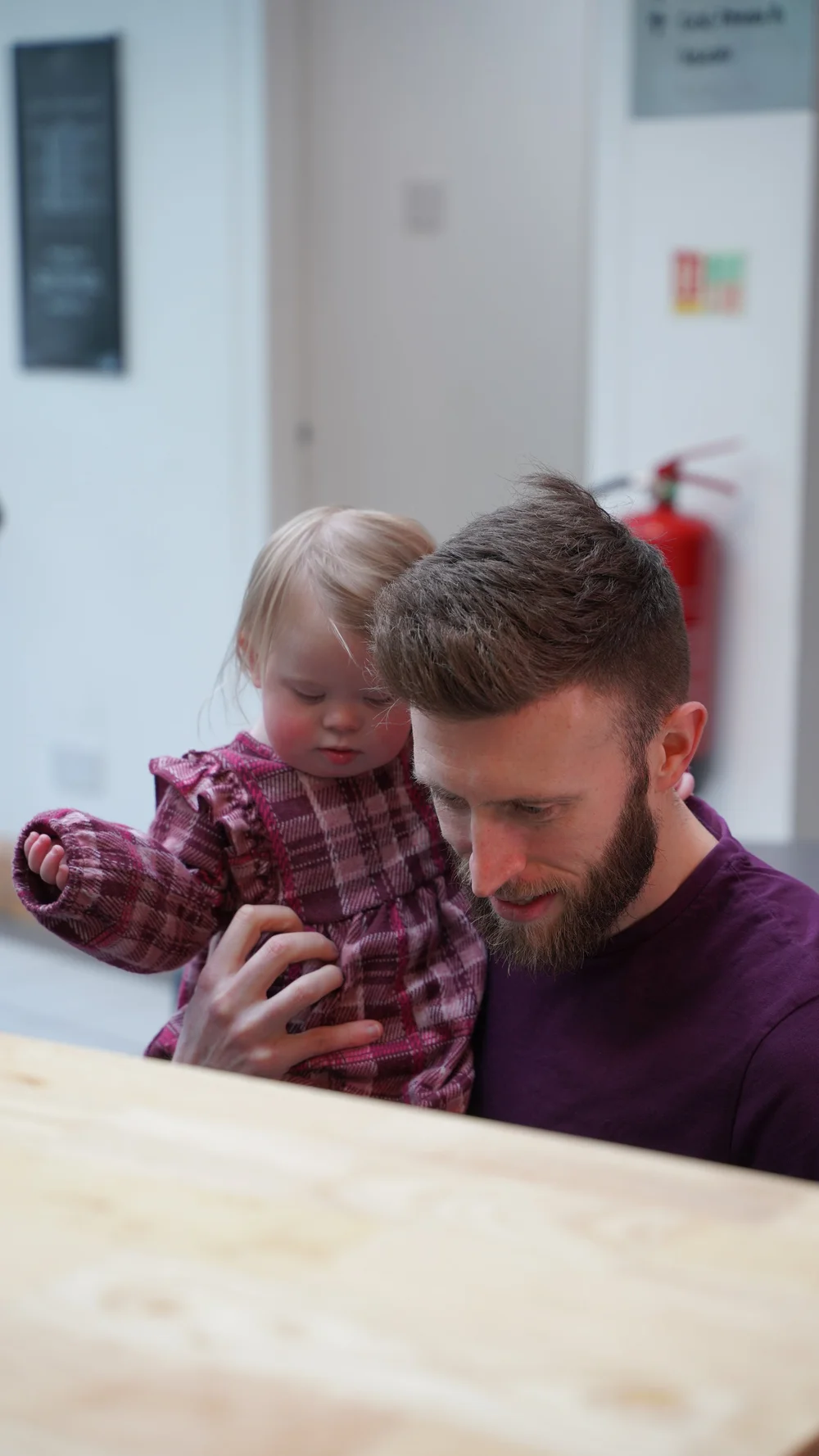 A young man holding a smiling little girl