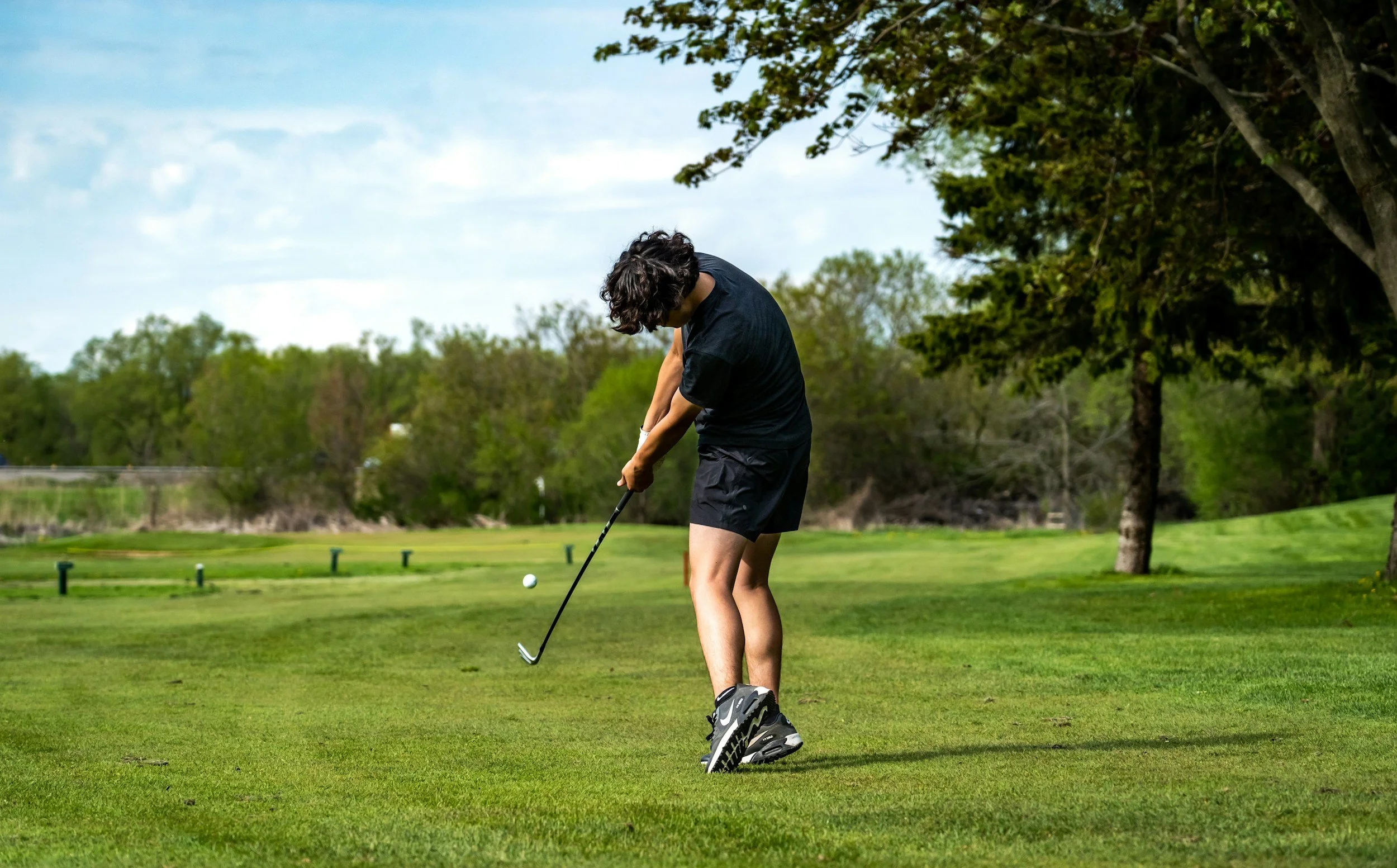 Golfing on a grass course.