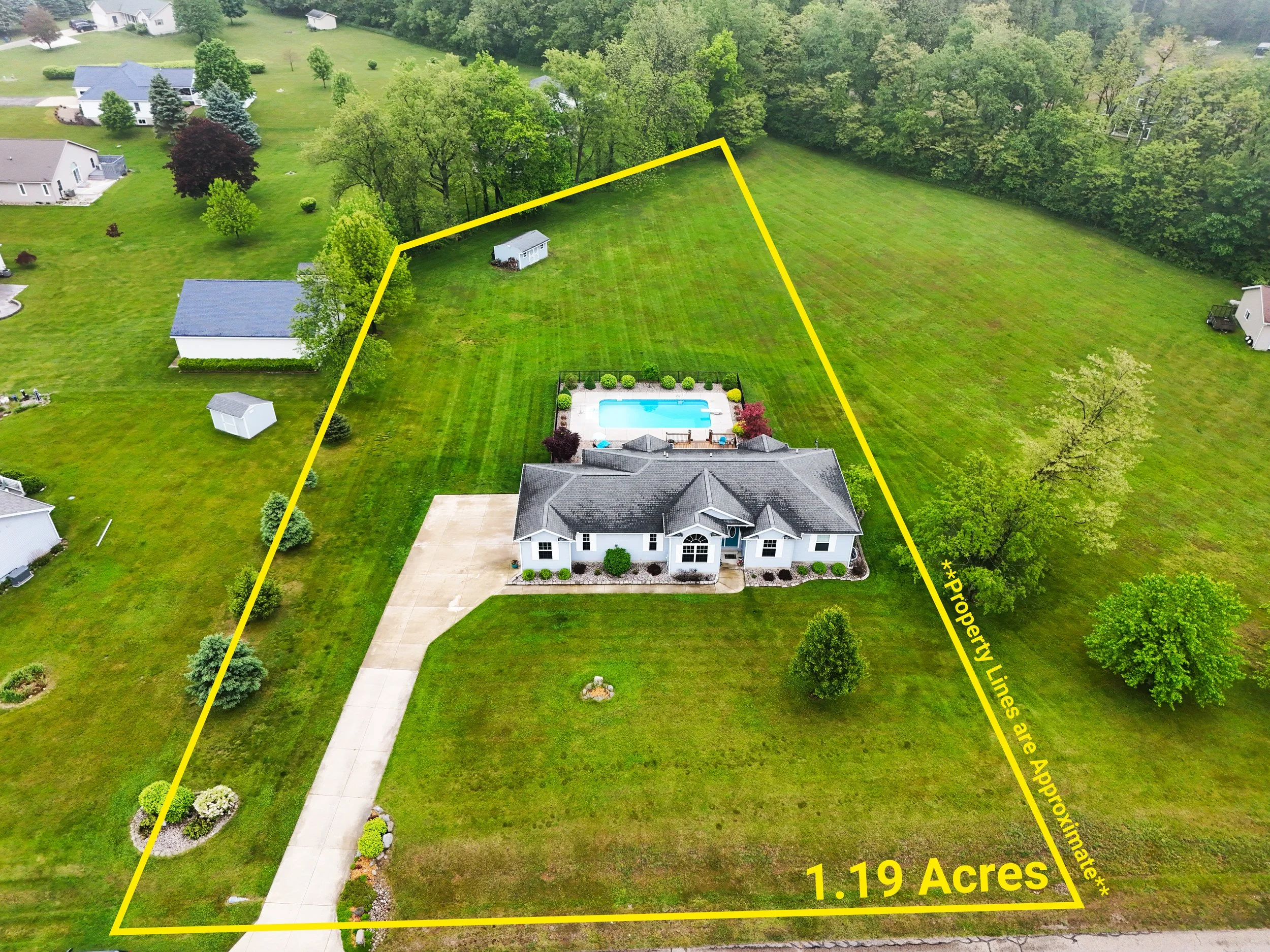Aerial view of a house on a 1.19-acre lot with a swimming pool, surrounded by a grassy lawn, trees, and neighboring houses, with property lines marked in yellow.