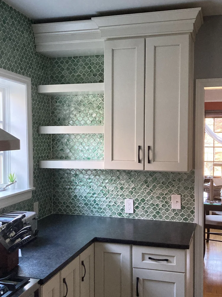 A modern Cincinnati living room mid-renovation, with a craftsman installing custom cabinetry, natural light streaming through new windows, and high-end tools neatly arranged. The scene conveys expertise, care, and a welcoming home environment.