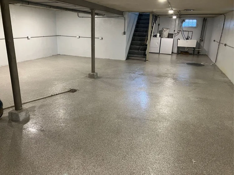 A Cincinnati home with a new architectural shingle roof, and a separate view of a garage floor with a glossy, blue-gray epoxy finish. Both areas are clean, bright, and showcase quality workmanship.