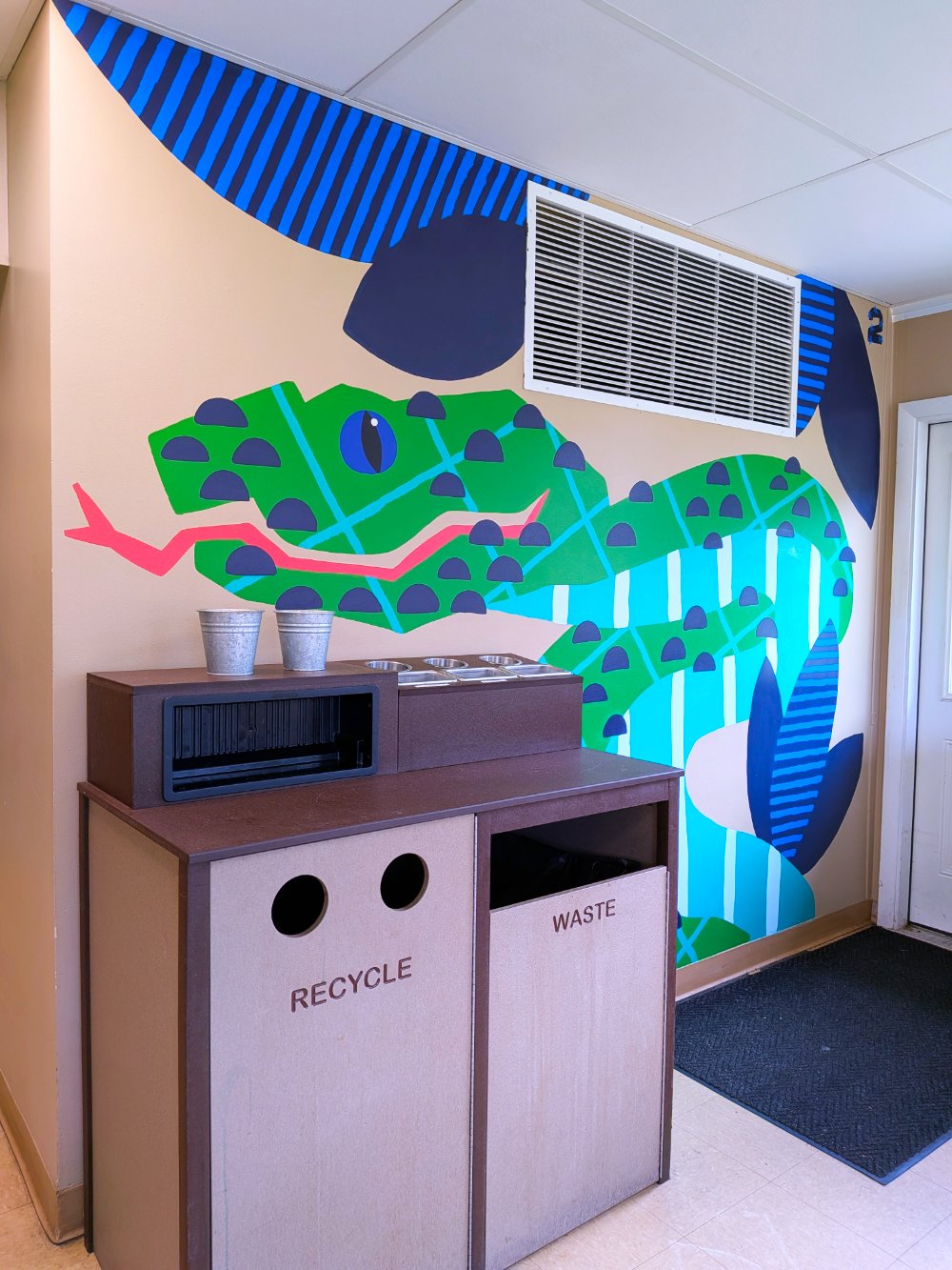 Sumatran Pit Viper mural in the Jungle Grill Building at the Racine Zoo, showing a colorful jungle snake and leaves with dots and stripes cropped to show fit on wall.