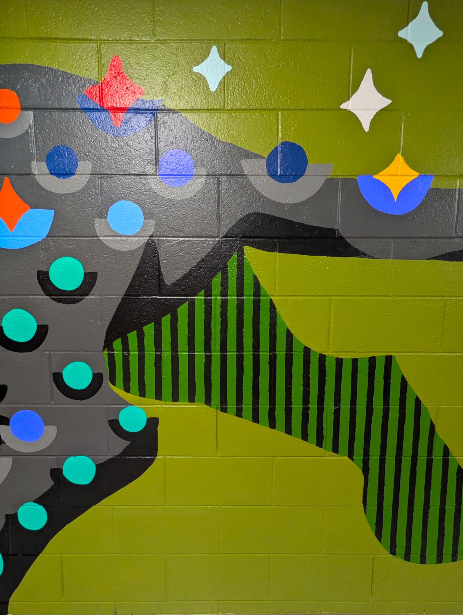 Bright Star Panther mural in an elementary school hallway, showing a black panther with colorful star and dot patterns cropped on back leg details.