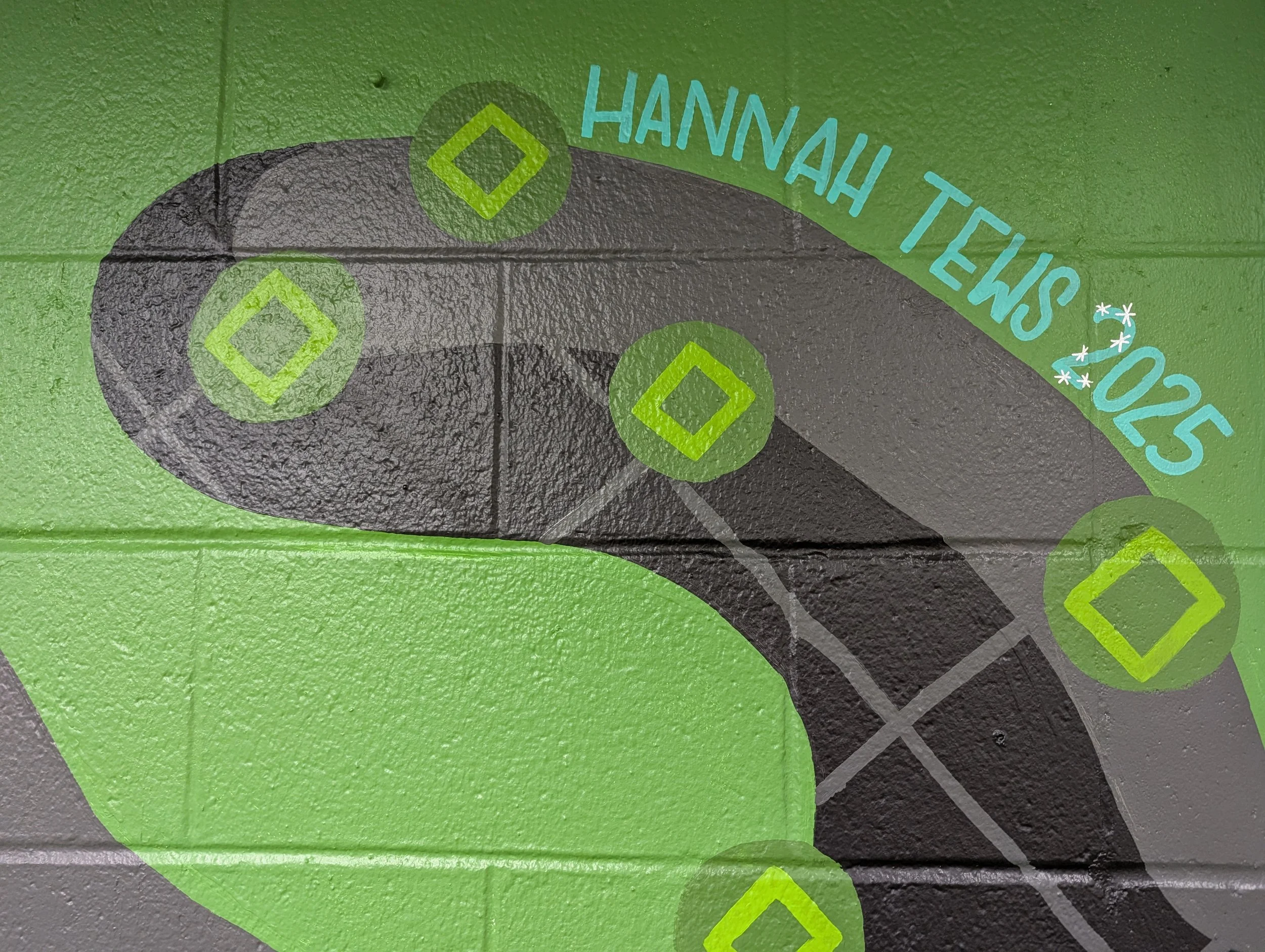 Cropped image of the black panther’s tail with Hannah Tews signature detail on the elementary school mural.