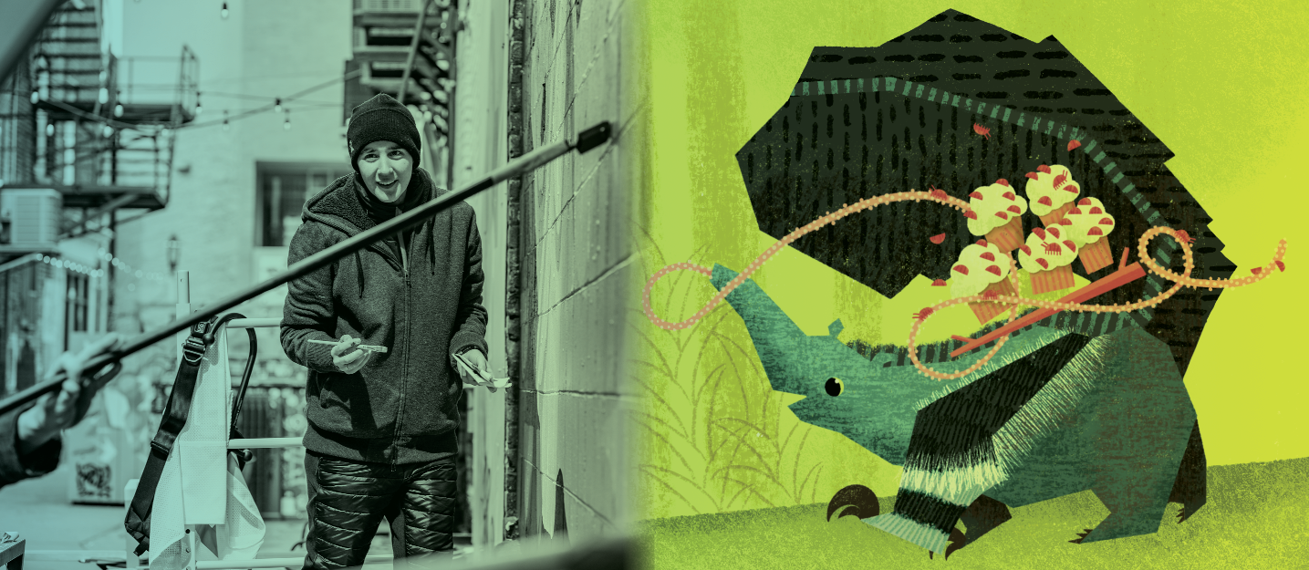 Artist Hannah Tews painting a mural in Black Cat Alley alongside a playful children's book illustration of an anteater with a tray of cupcakes on its back.