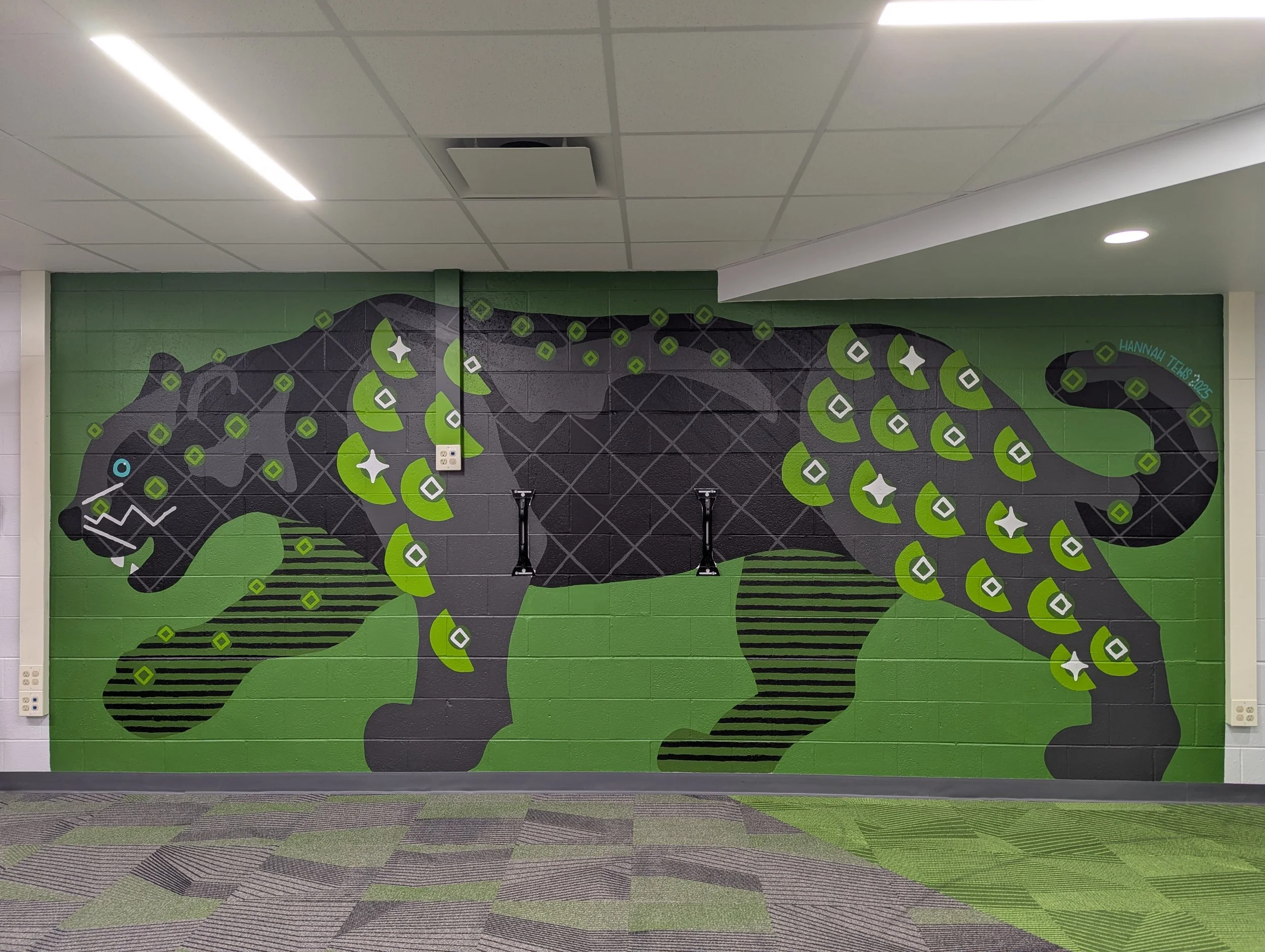 Full wall image of black panther elementary school mural with geometric shapes in blacks, greys, and greens.