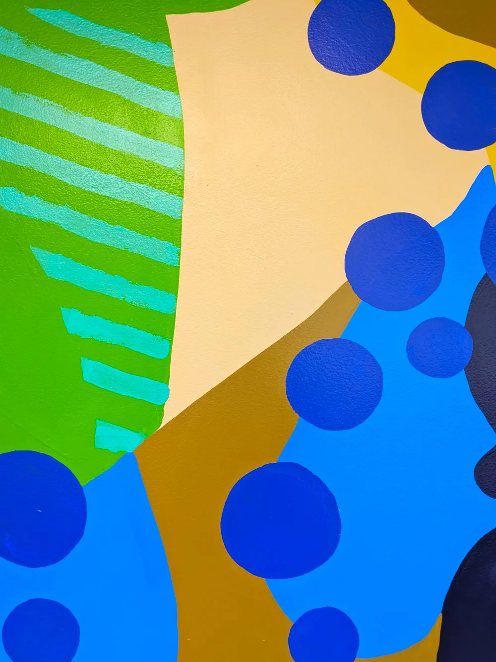 Clouded Leopard mural in the Jungle Grill Building at the Racine Zoo, showing a colorful jungle cat face and leaves with dots and stripes cropped close to show pattern detail.