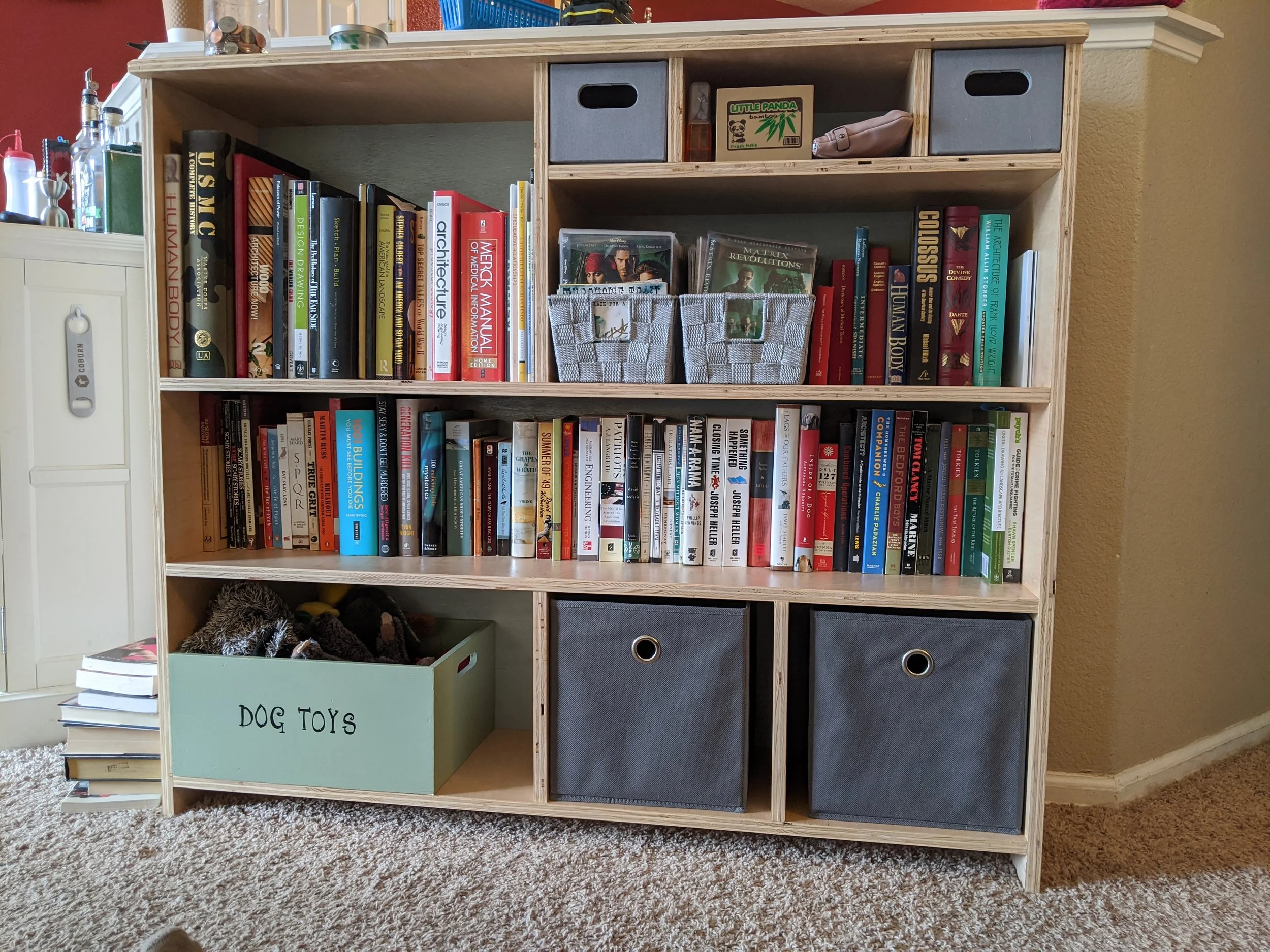 A plywood bookshelf with built-in storage.