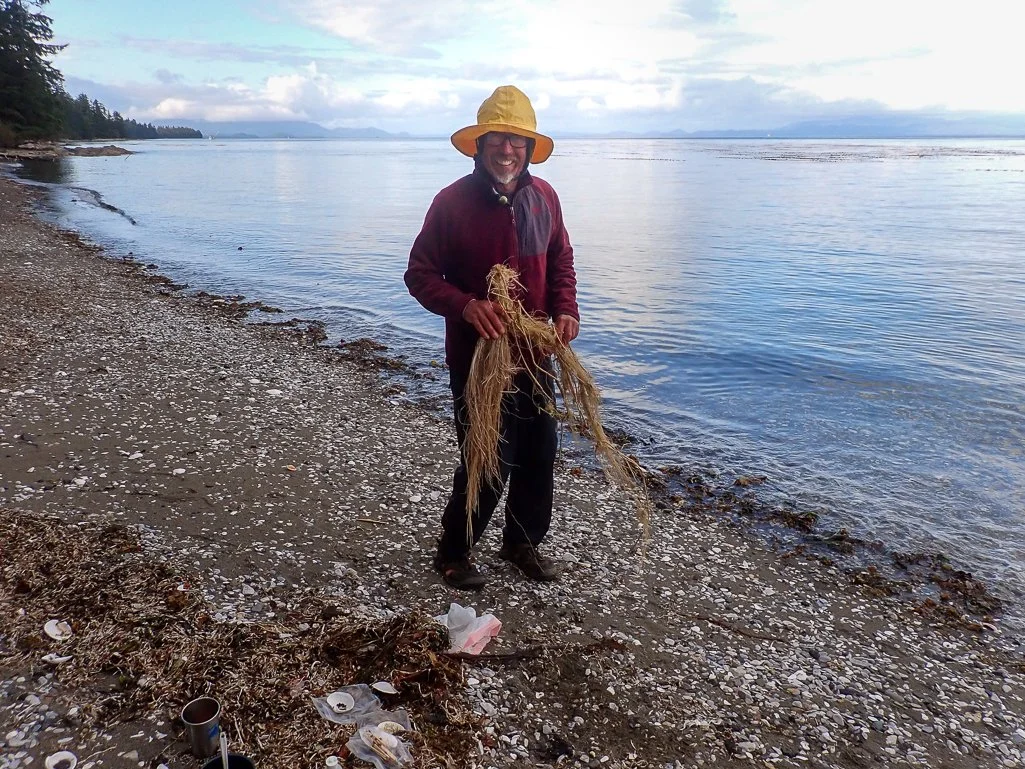Ken's full belly of salmon prompts him to do a hula dance with beach seaweed.