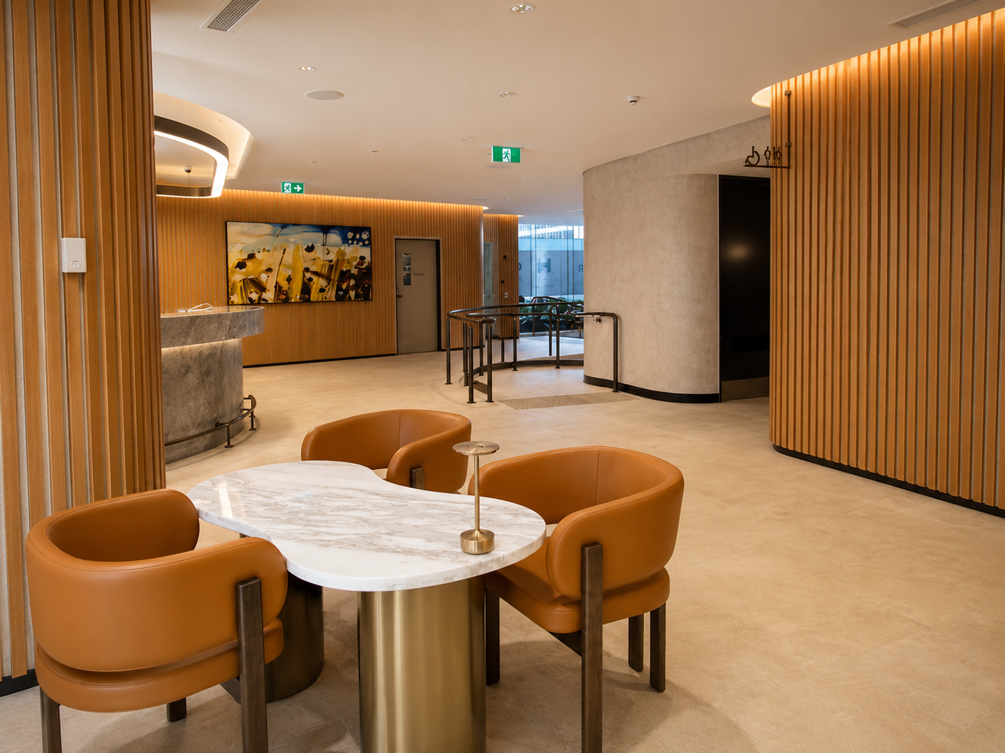 Modern hotel lobby with a white marble table surrounded by four orange leather chairs. The spacious area features wooden slat walls, a curved reception desk, a large colorful abstract painting, and glass doors leading outside. The design is sleek and