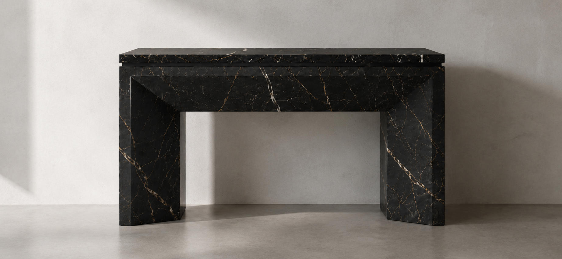 Black marble fireplace with gold veining against a white wall.