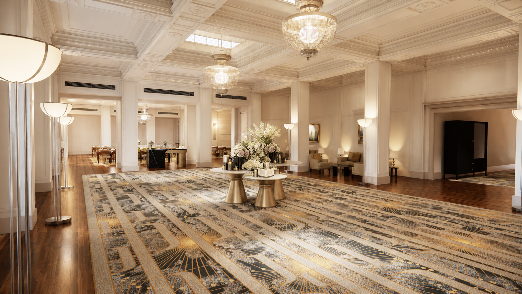 Elegant hotel lobby with a high ornate ceiling, large chandeliers, a patterned area rug, and floral arrangements on modern gold tables. Comfortable seating and wall sconce lighting add to the luxurious atmosphere.