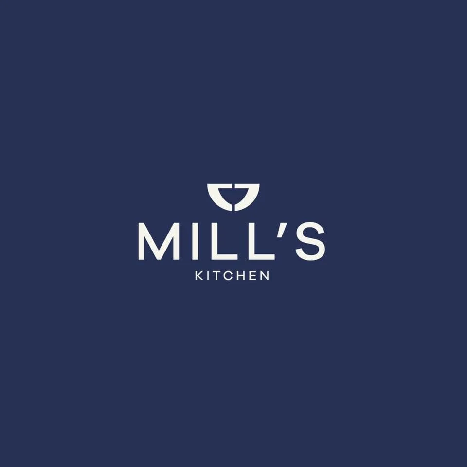 Logo for Mill's Kitchen with a navy blue background and a minimalist emblem above the text.