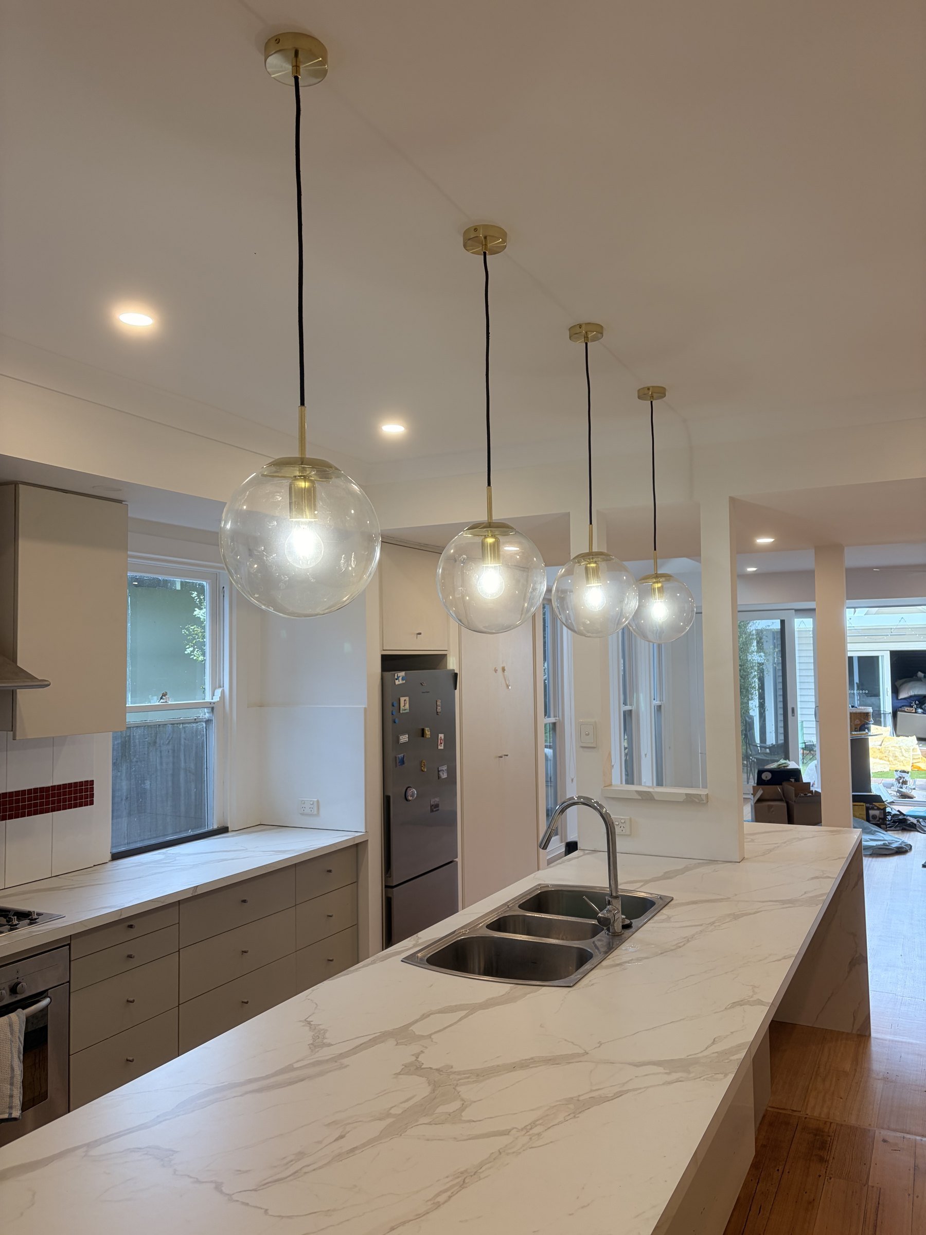 Kitchen renovation with stone island bench and pendant lights by Oriondo Projects