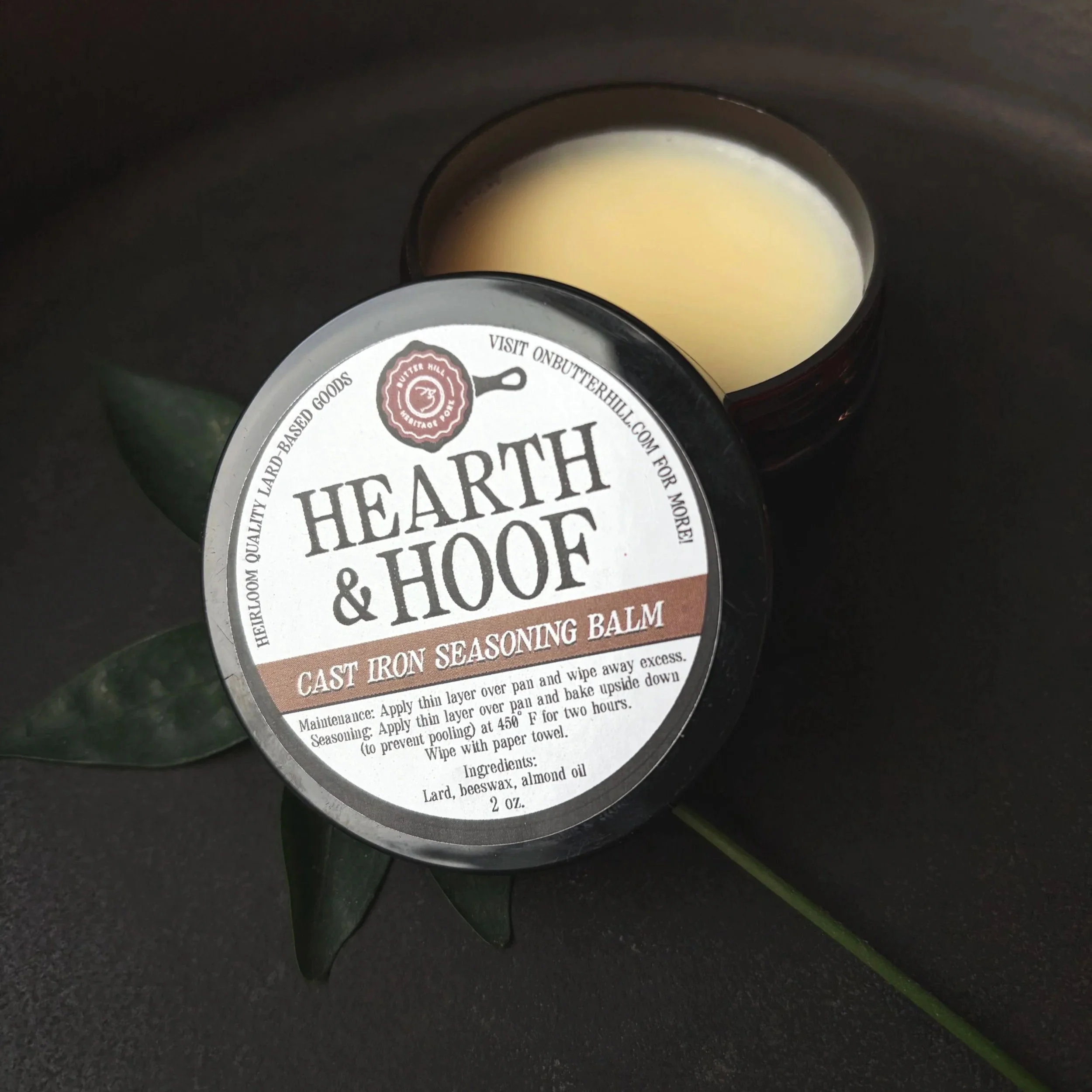 hearth and hoof cast iron seasoning balm displayed open on a dark backdrop