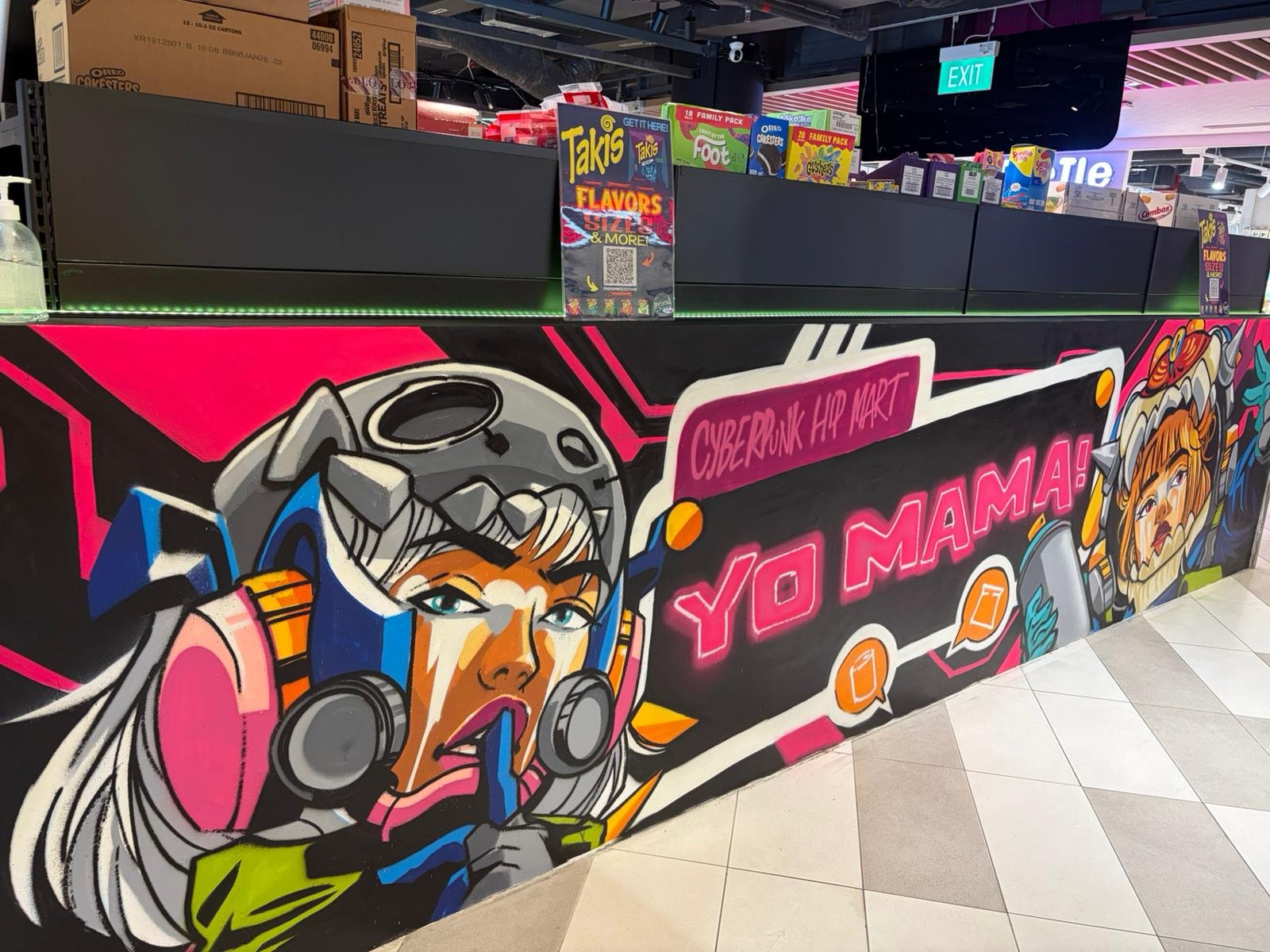 Colorful graffiti-style mural with a female character dressed as a futuristic warrior, wearing a helmet with cat ears, and text that reads 'Cyberpunk Hip Mart' and 'Yo Mama!' in a shopping mall.