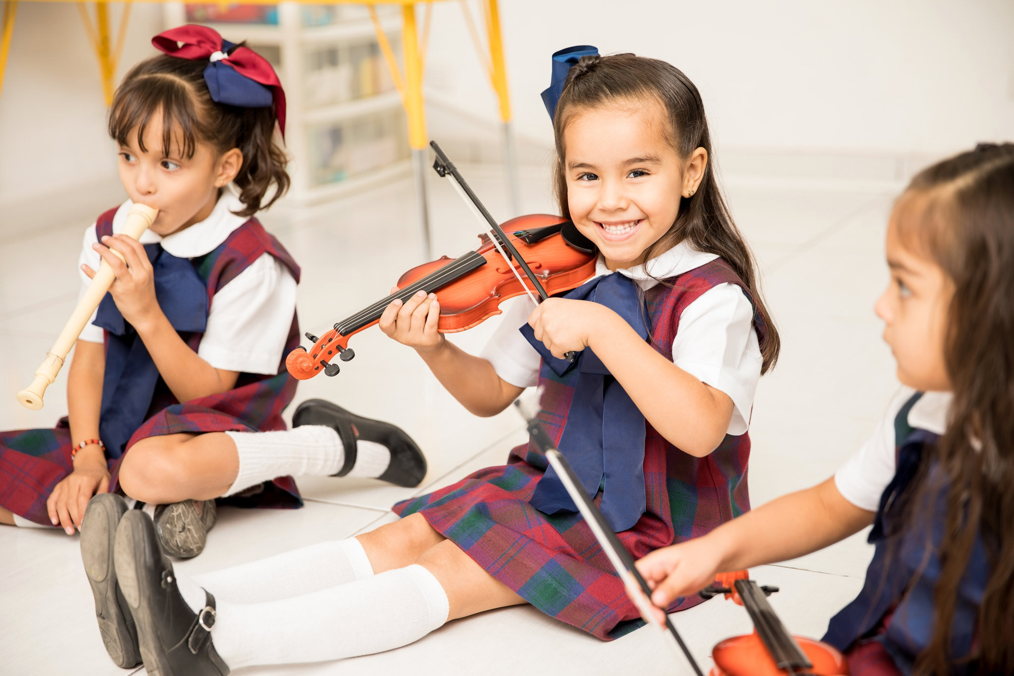 Happy girl playing the violin in preschool