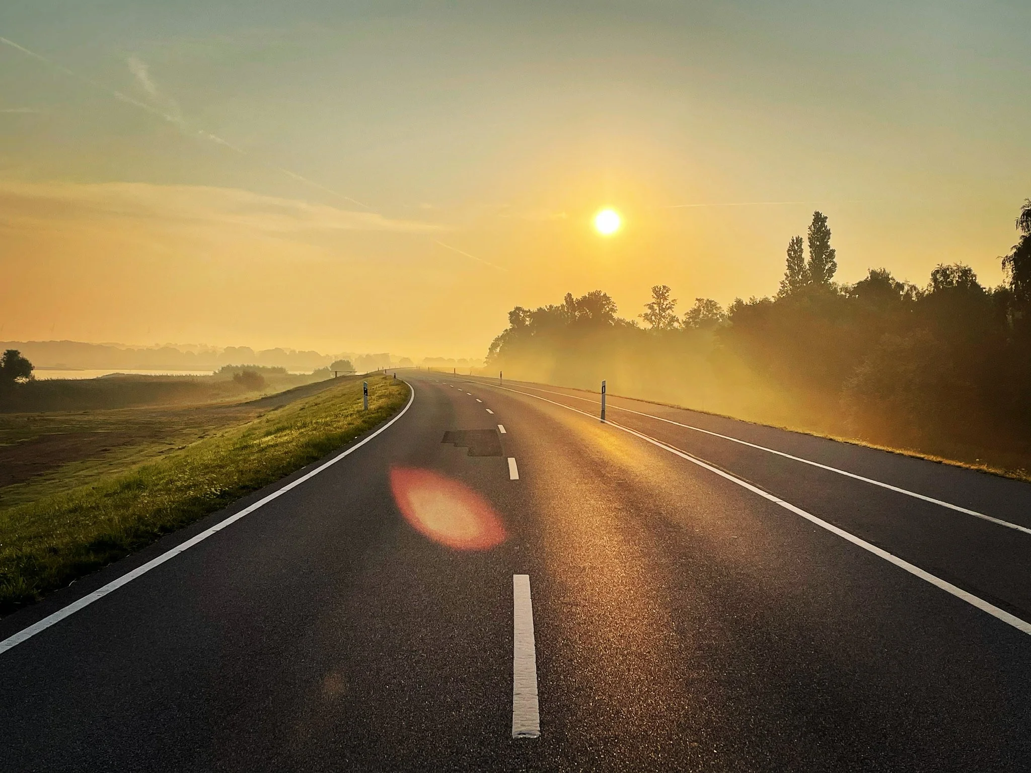 Sonnenaufgang über dem Elbdeich mit Blick über die Straße für Auto-Fotoaufnahmen nahe der Elbe04 Location bei Hamburg