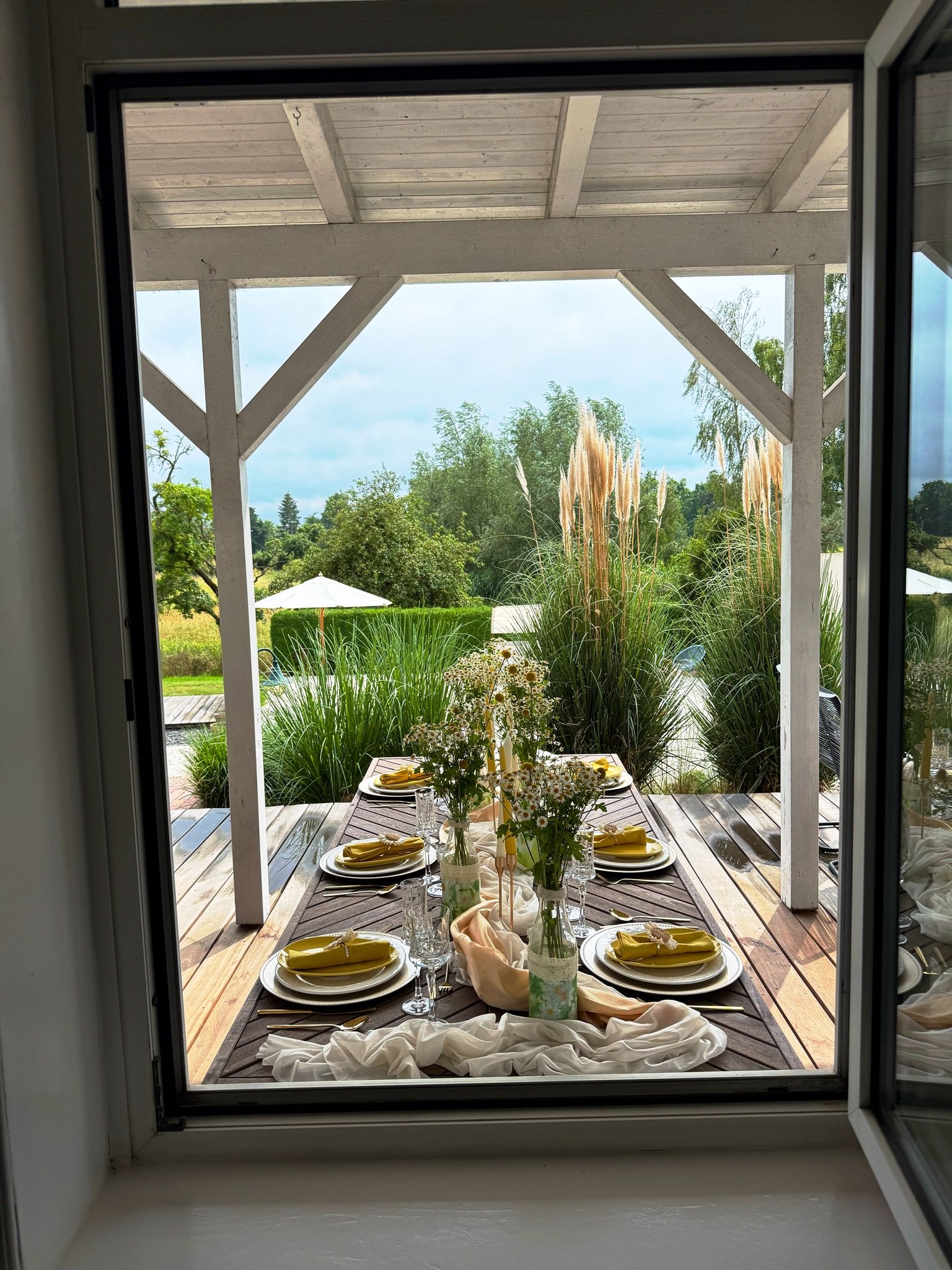 Überdachte Terrasse mit Lounge-Bereich und Blick in den Garten