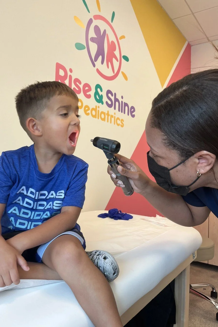 Pediatrician examining a young boy's throat at Rise & Shine Pediatrics in Boca Raton