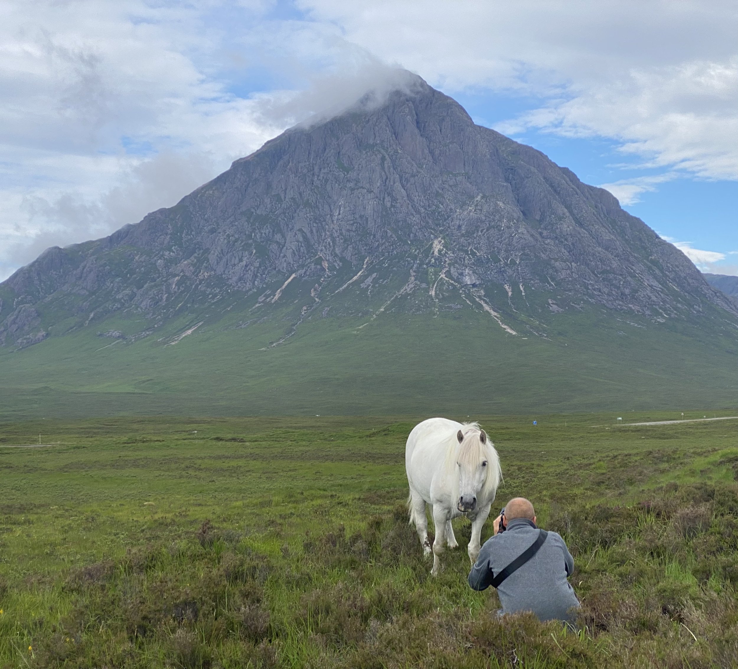 Ian Hull photographing a white highland pony in front of the Buchaille etive mor in Glencoe, Scotland. Capturing the photograph named, The Buchaille.