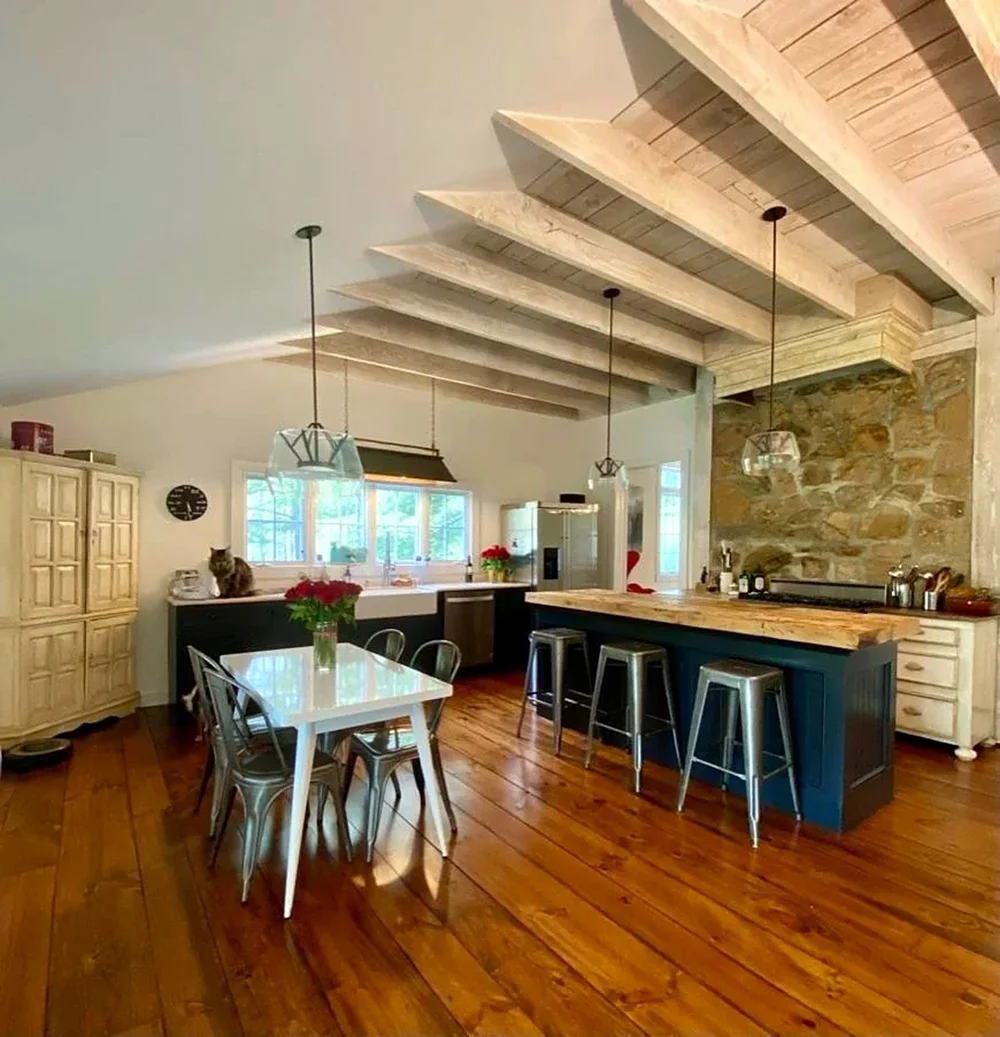 Farmhouse kitchen with whitewashed beams, a stone wall and a navy island, Basking Ridge