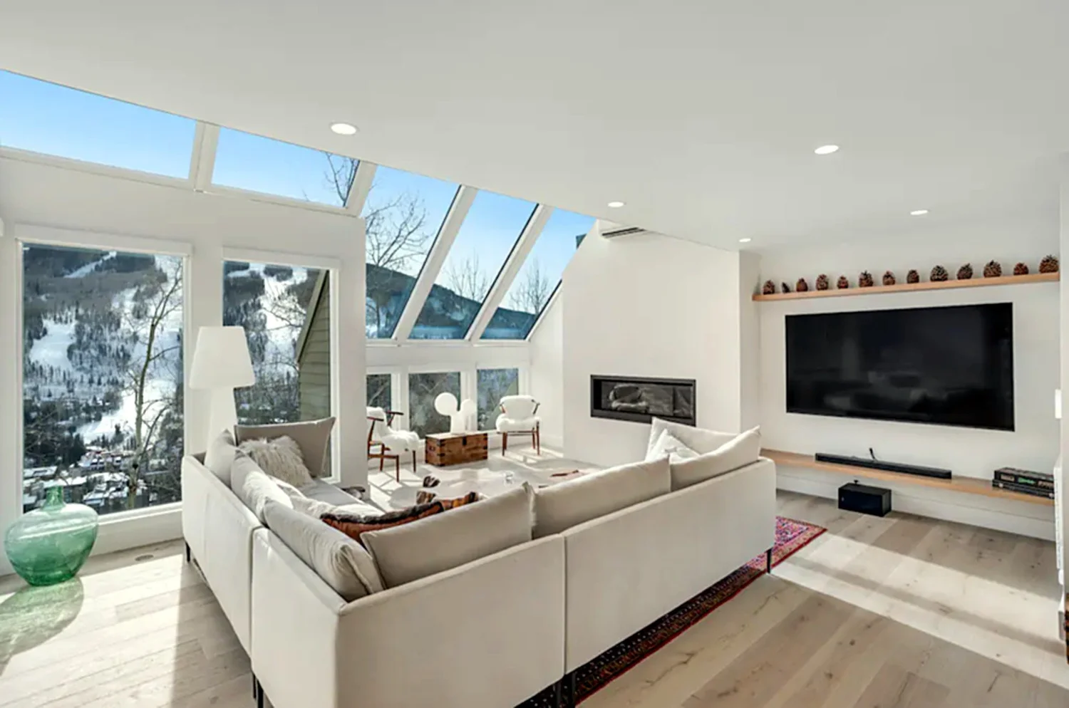 Living room with a white sectional and walls of glass, Mountain Retreat in Vail