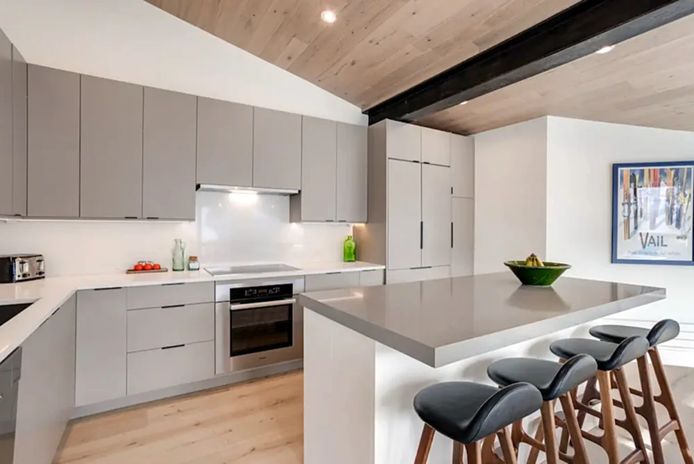 Bright kitchen with a long island under a wood ceiling, Mountain Retreat in Vail