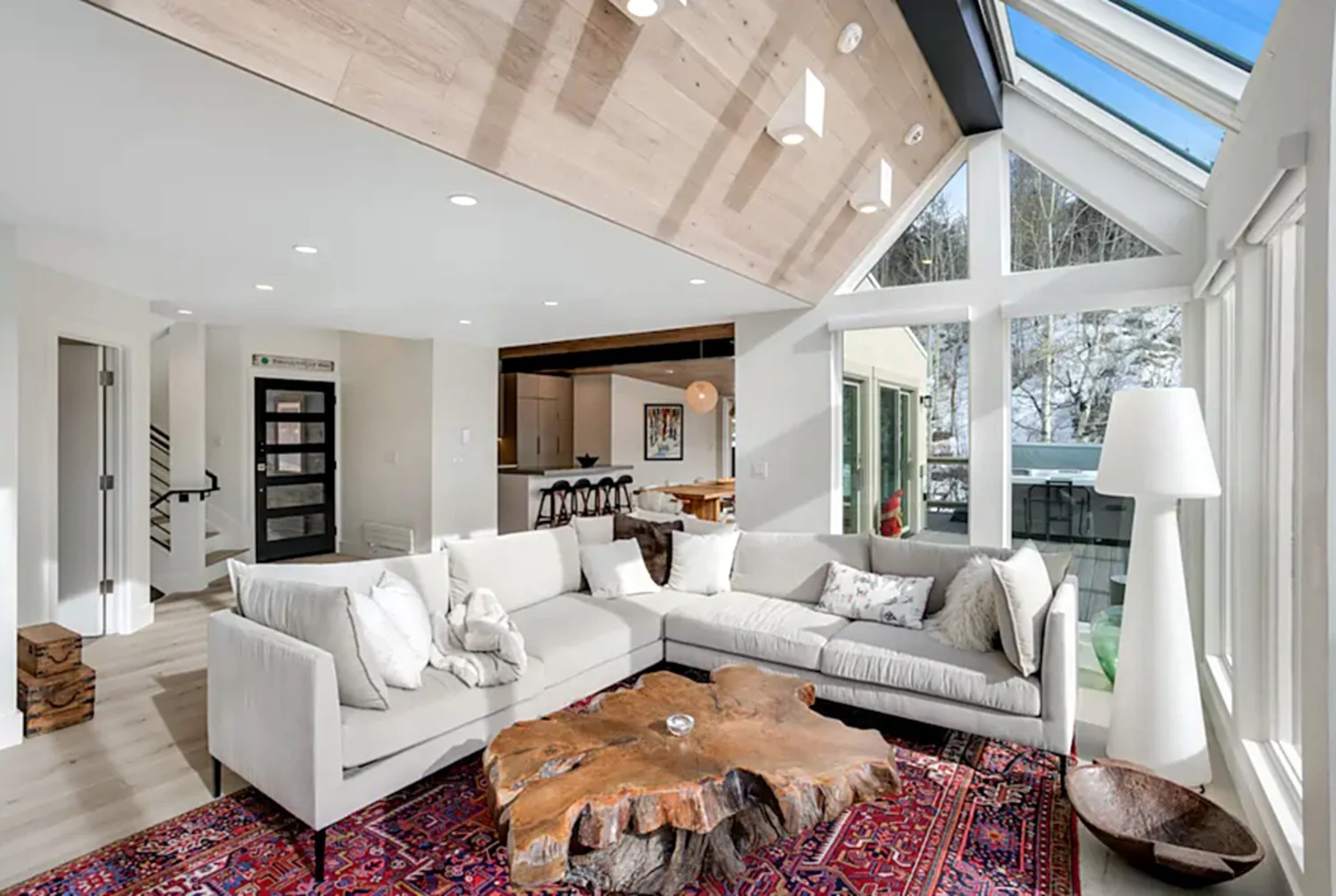 Living room with a white sectional, live-edge table and ski-slope views, Mountain Retreat in Vail