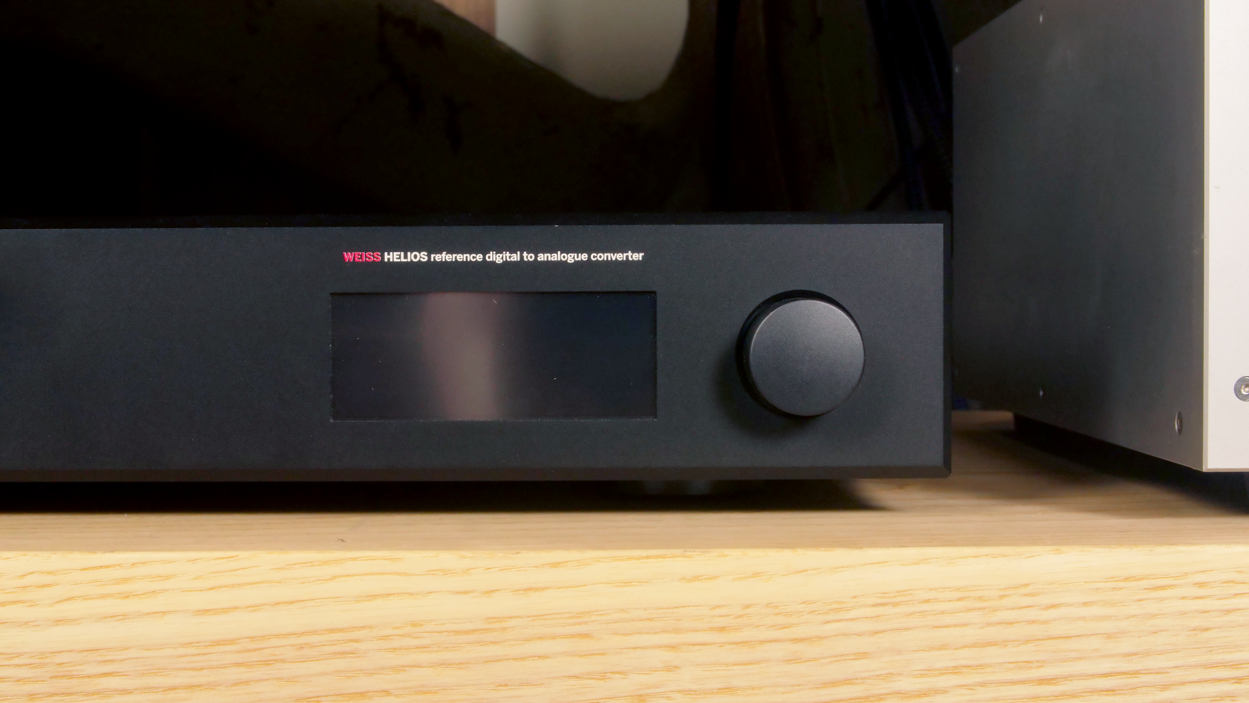 Weiss Helios DAC interface in black on a wooden audio equipment rack