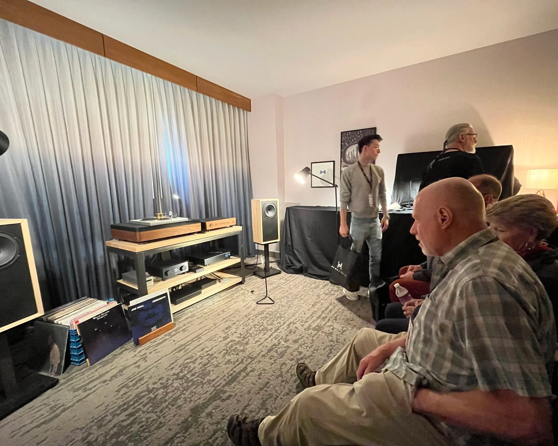 A view of Fern & Roby's listening room at Axpona 2025, featuring the Raven II speakers on isolation stands, the Fern & Roby equipment rack, Amp No 2, and Linear Tube Audio and Grimm  components.