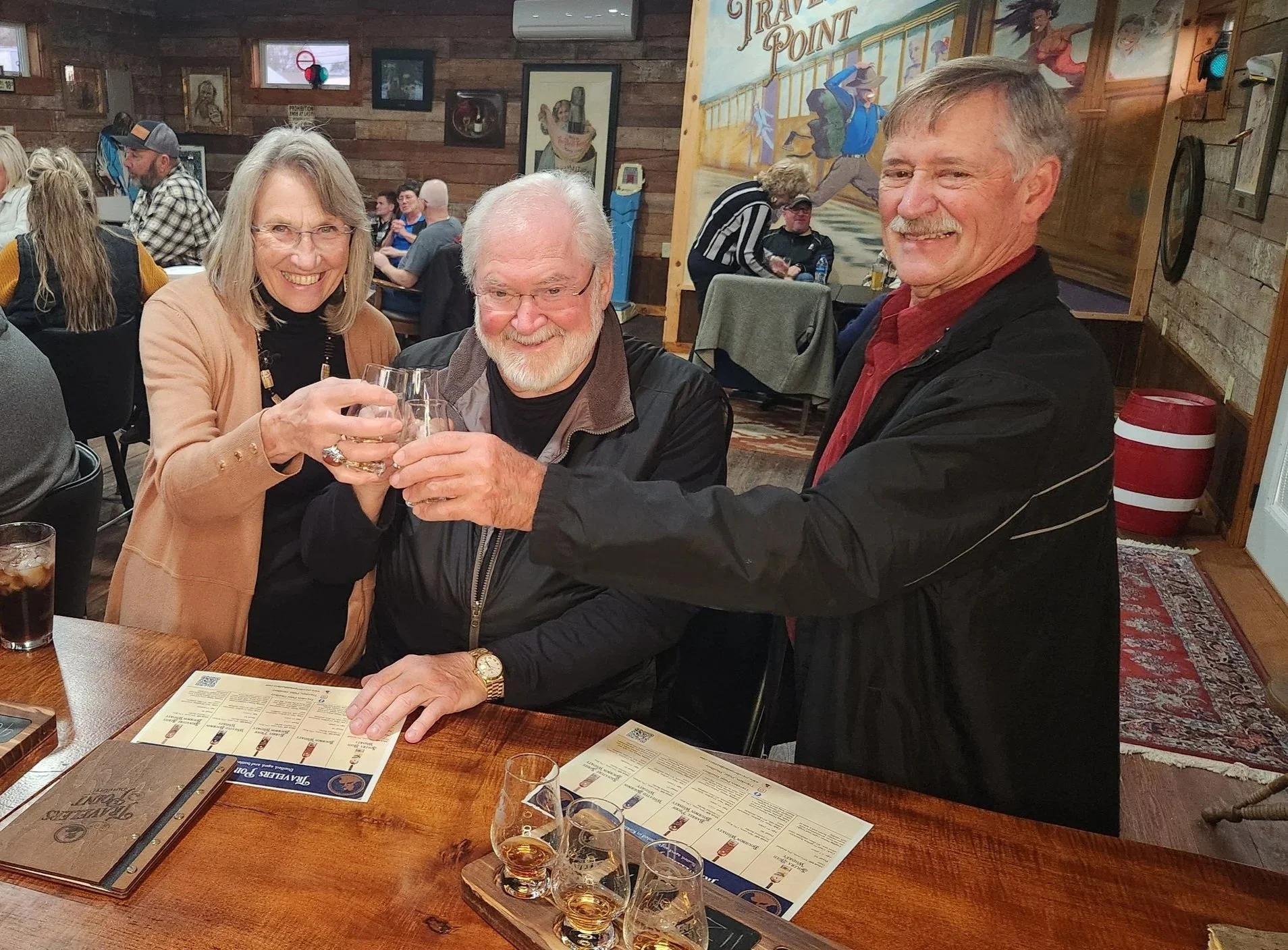 three patrons at the bar cheersing